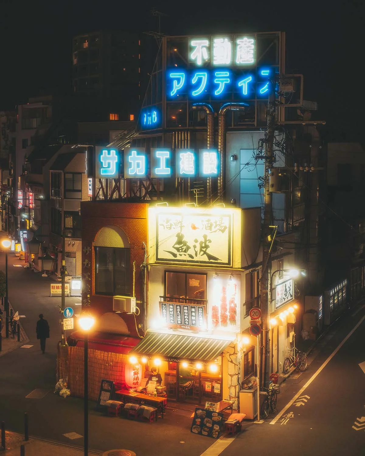 Photographie de rue nuit Tokyo ambiance cyberpunk enseignes néons lumineux japonais restaurant izakaya immeubles. Urbanisme dense vie nocturne éclairage artificiel street photography Japon.