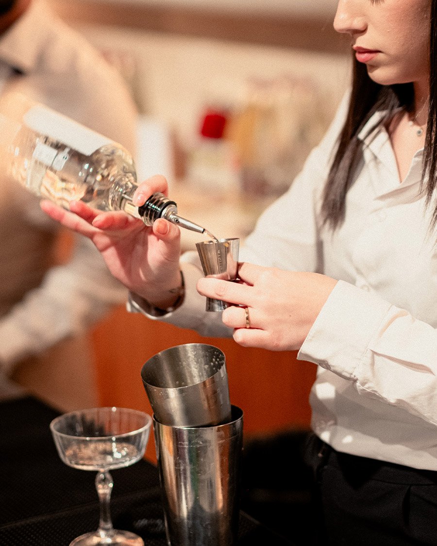 Préparation de cocktails par un mixologue lors d'une soirée d'entreprise. Mise en valeur des animations traiteur et de l'ambiance festive de vos événements corporate.