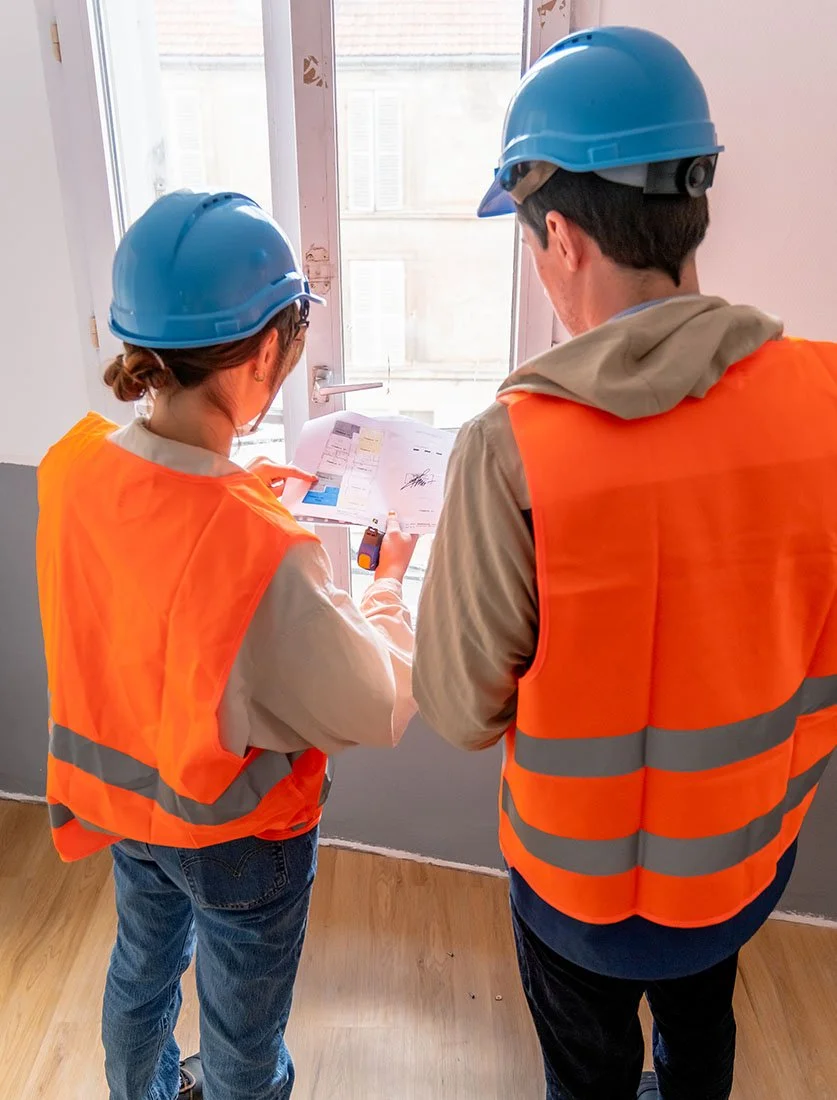 L'humain au cœur du chantier : prise de cotes et vérifications techniques par des ouvriers lors d'une rénovation.