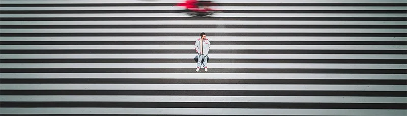Portrait souriant de Dimitri Weber, photographe et vidéaste professionnel basé en Île-de-France, portant un appareil photo en bandoulière. Image de présentation du fondateur.