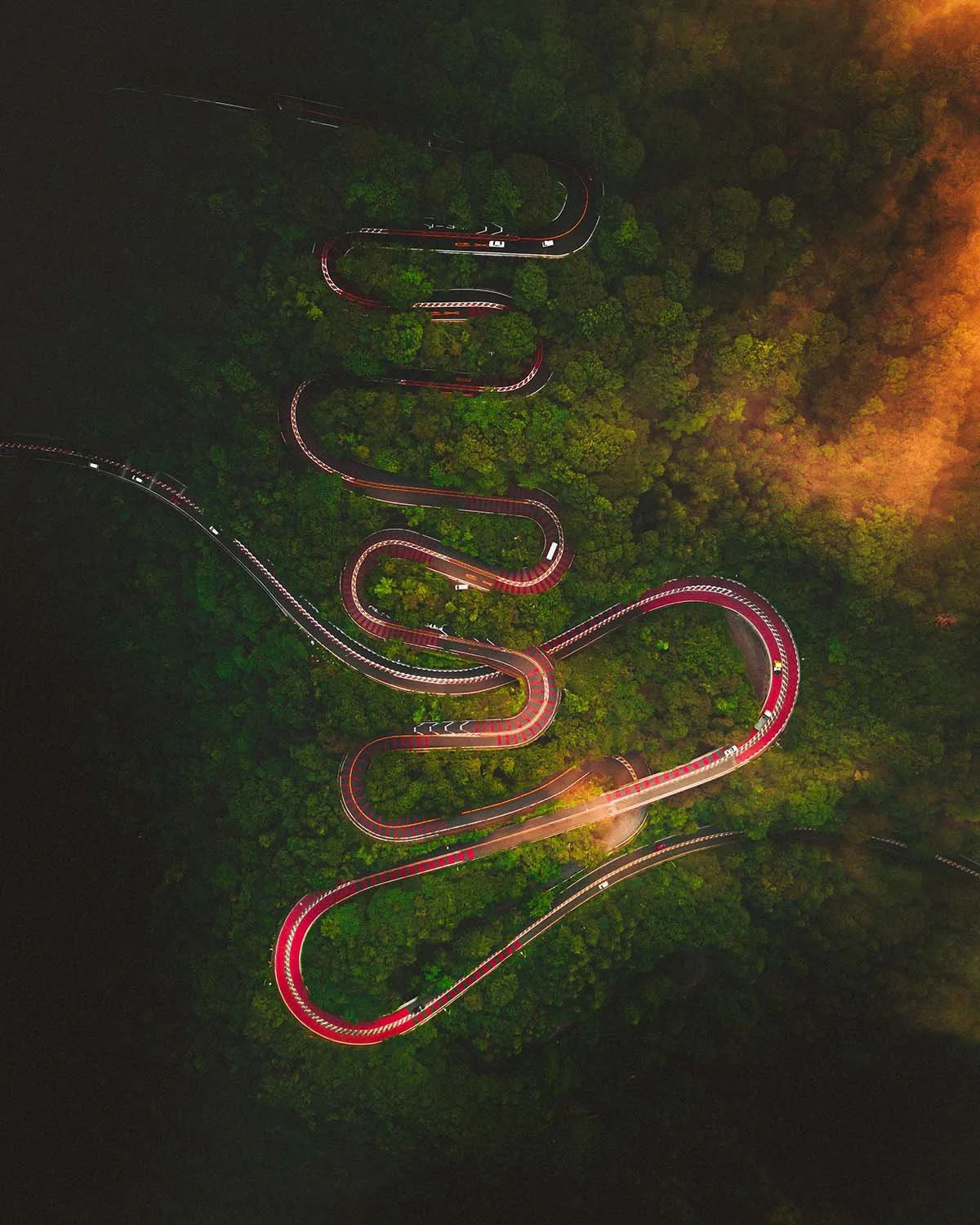 Serpent de lumière dans la montagne. Les phares des voitures dessinent les courbes de la route la nuit.