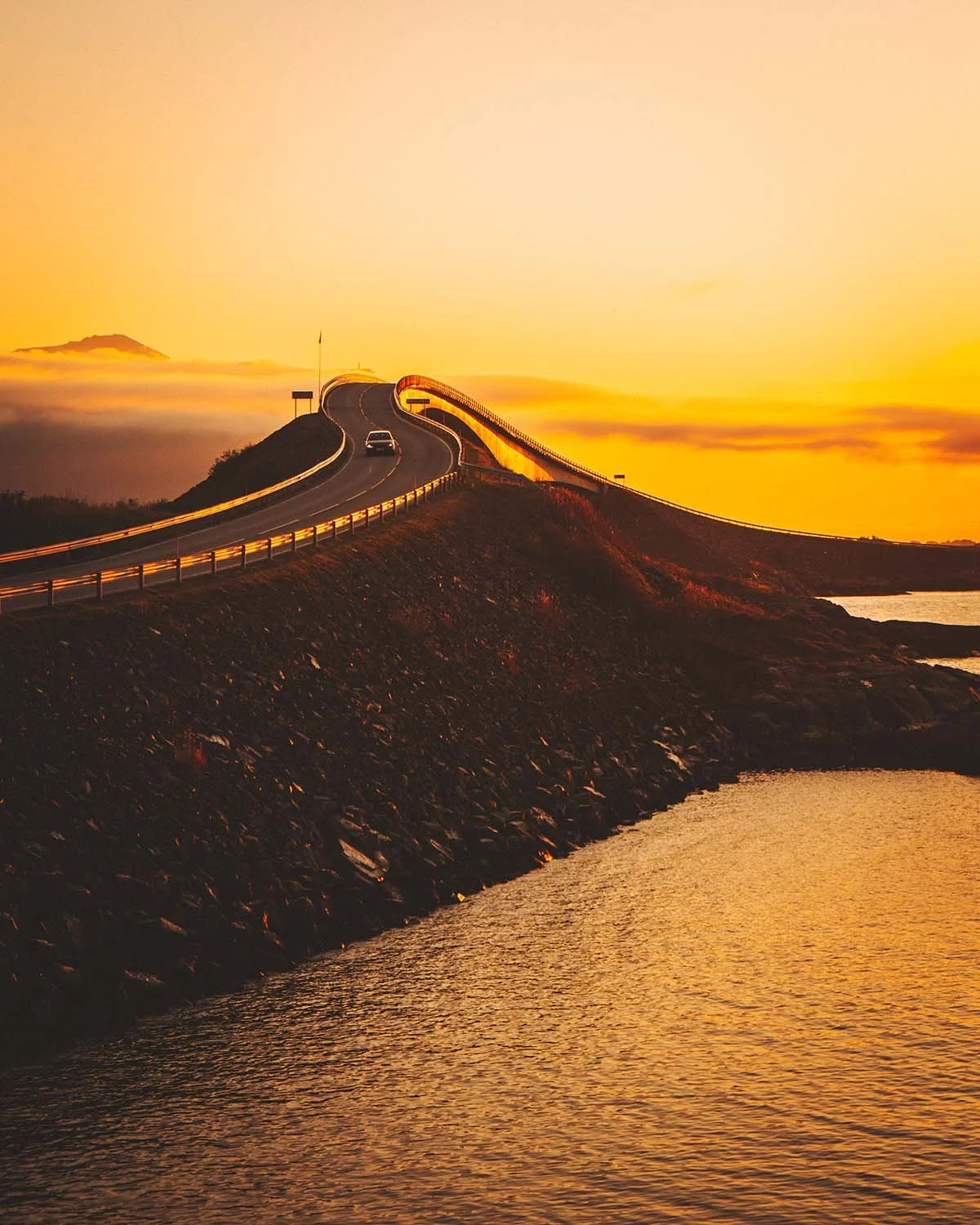 La route de l'impossible. Le pont Storseisundet semble bondir vers le ciel au coucher du soleil.