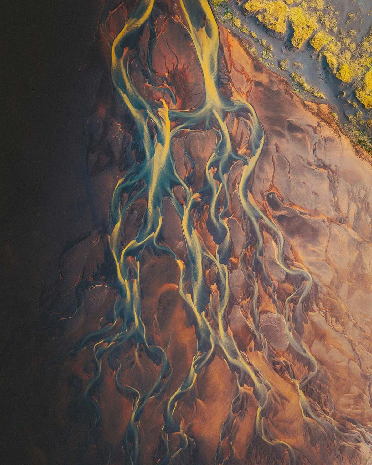 Explosion de couleurs volcaniques vue du ciel : rivière islandaise aux teintes jaune soufre et orange oxyde de fer.