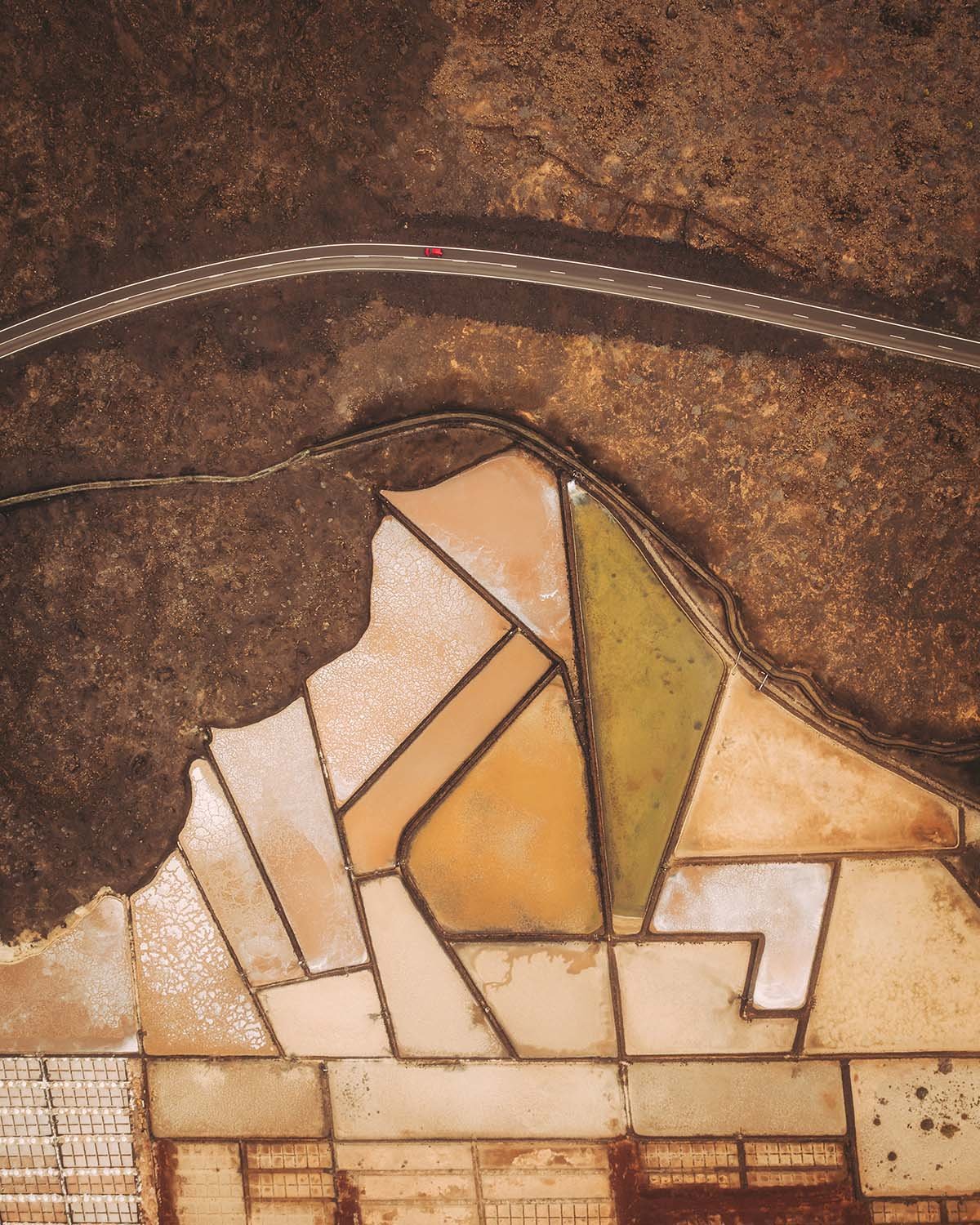Vue top-down (zénithale) géométrique des marais salants de Salinas de Janubio à Lanzarote. Textures et couleurs pastel capturées par Dimitri Weber.