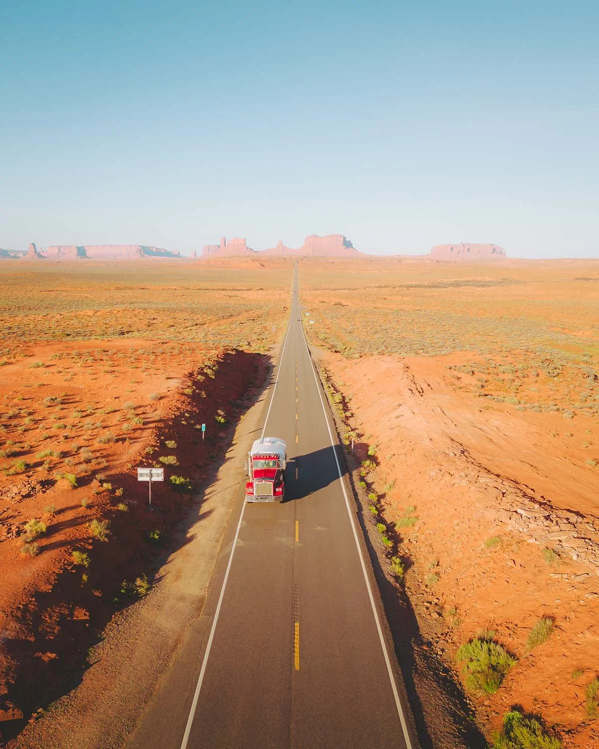 La célèbre longue route rectiligne (Highway 163) menant à Monument Valley, connue sous le nom de Forrest Gump Point. Photo de voyage iconique mettant en valeur l'immensité du paysage américain.