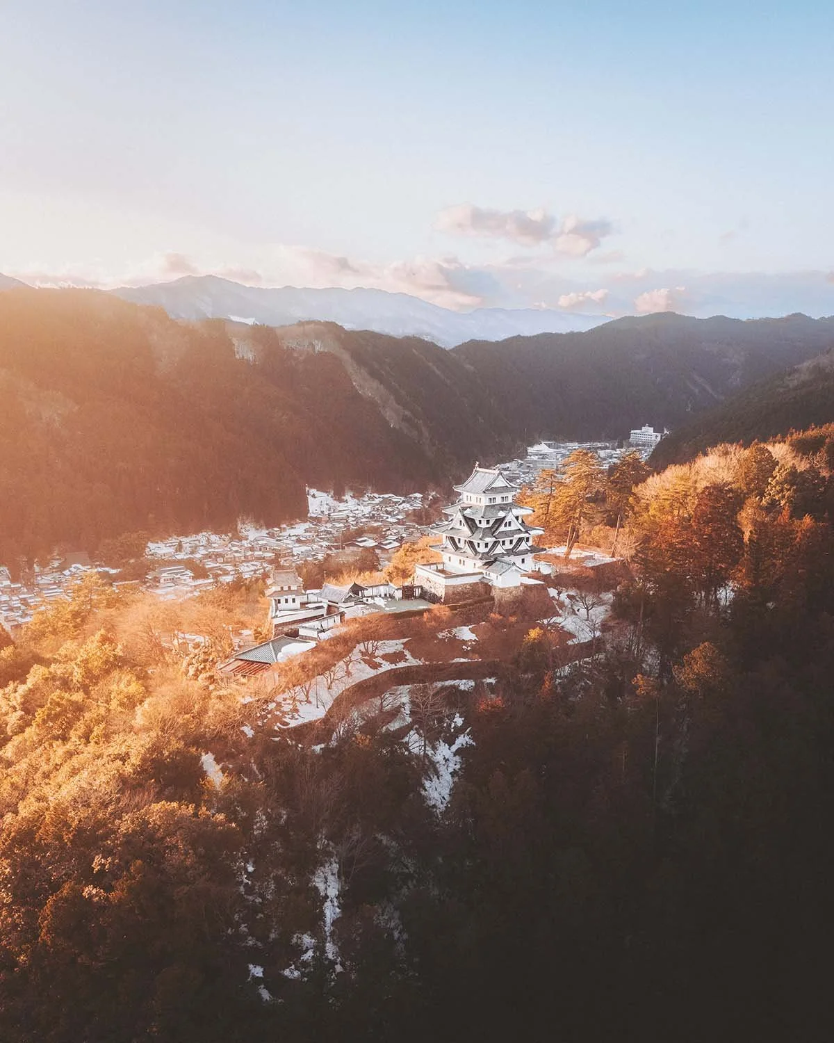 Vue aérienne époustouflante du château de Gujo Hachiman (Le château dans le ciel) émergeant de la brume matinale et de la forêt enneigée dans la préfecture de Gifu.