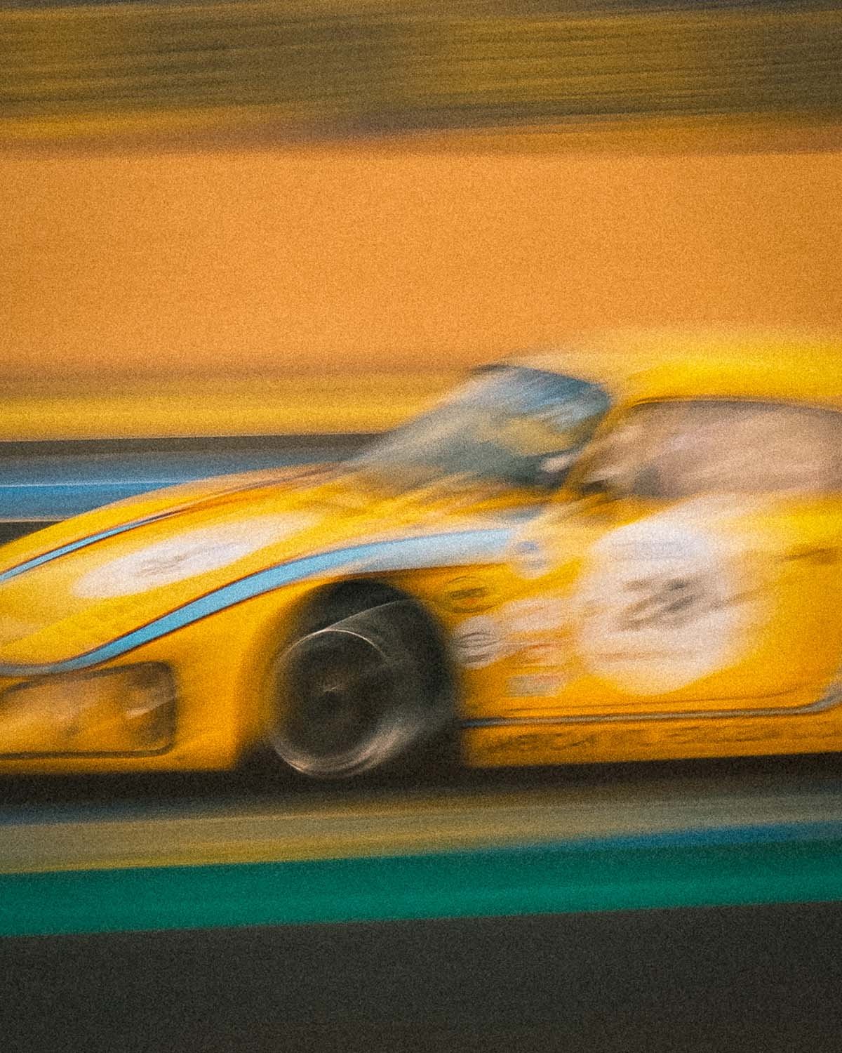 Voitures de course d'époque en pleine action sur le circuit des 24 Heures lors du Le Mans Classic. Vitesse et patrimoine automobile capturés par Dimitri Weber.