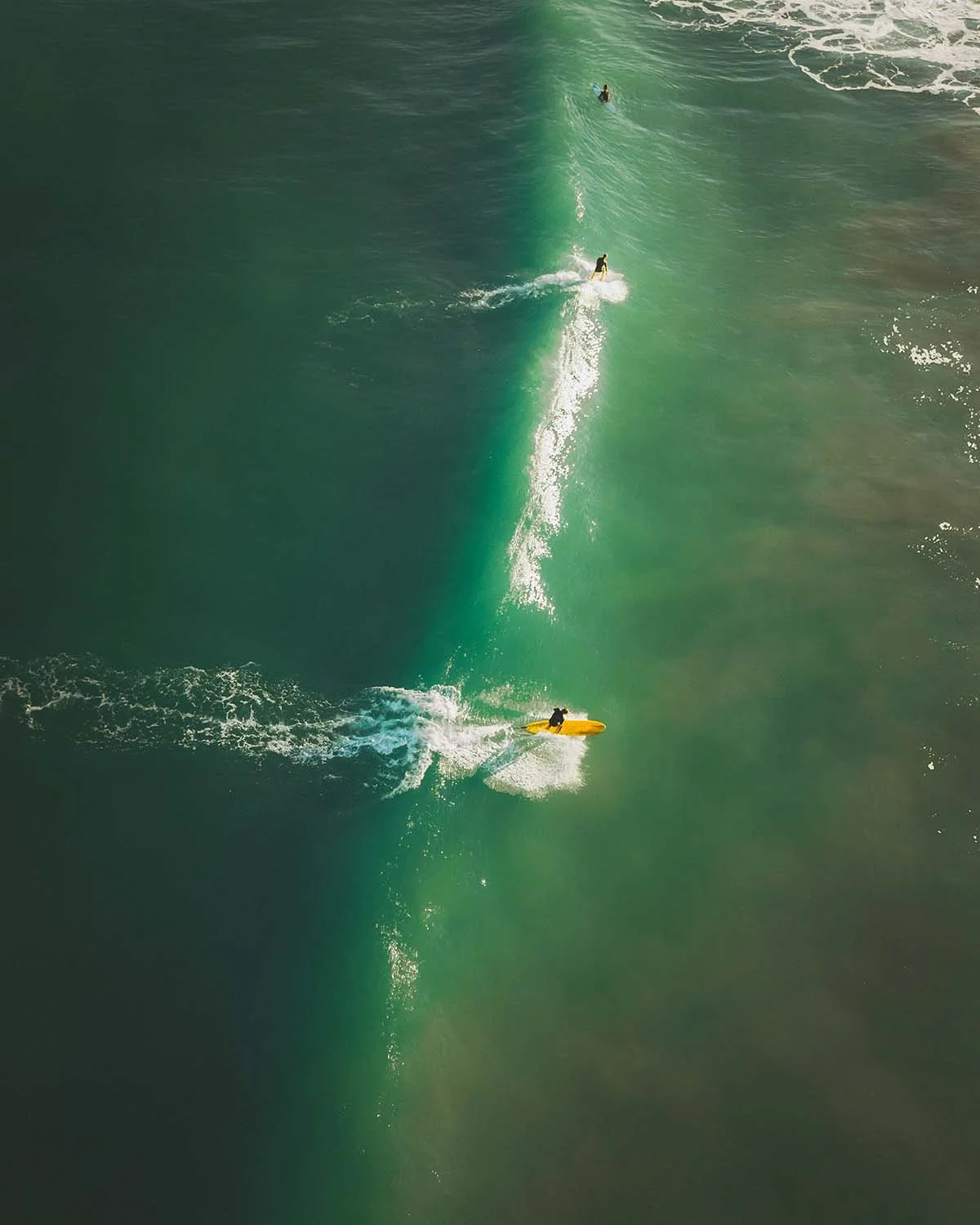 Vue aérienne d'un groupe de surfeurs au "lineup" attendant la vague parfaite sur une plage de Biarritz. Photographie de sport et lifestyle au Pays Basque.