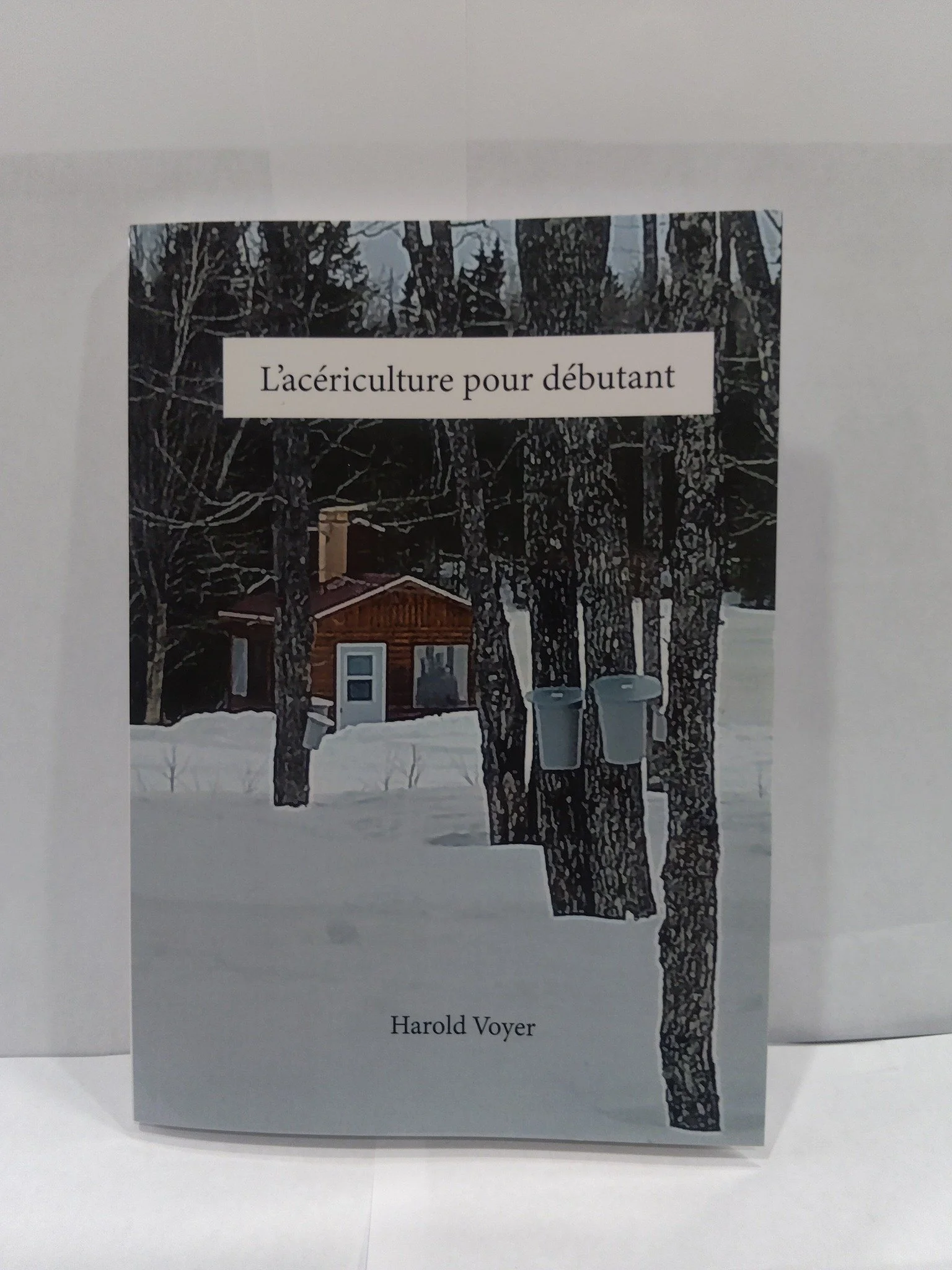 Livre intitulé 'L'aériculture pour débutant' par Harold Voyer, avec une couverture montrant des arbres et une petite maison en bois dans un paysage enneigé.