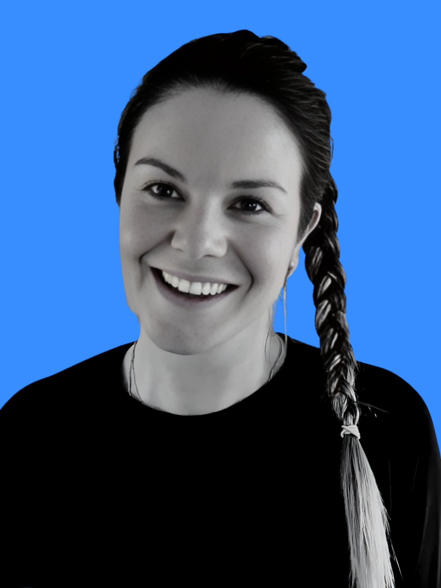 Close-up portrait of a woman with a braid hairstyle, smiling, with a blue background.