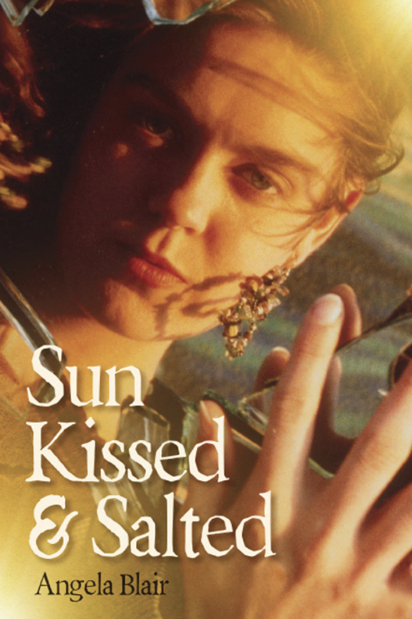 Book cover with a woman facing the camera, holding a branch with leaves, backlit by sunlight. The title is 'Sun Kissed & Salted' by Angela Blair.