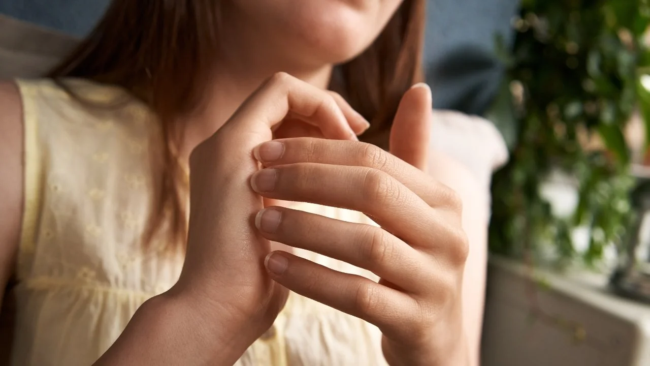 Close-up of a woman holding her hands together outdoors