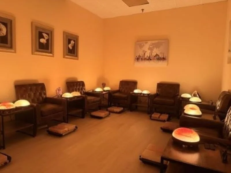 Top view of hands resting on legs, with well-manicured nails and smooth skin.