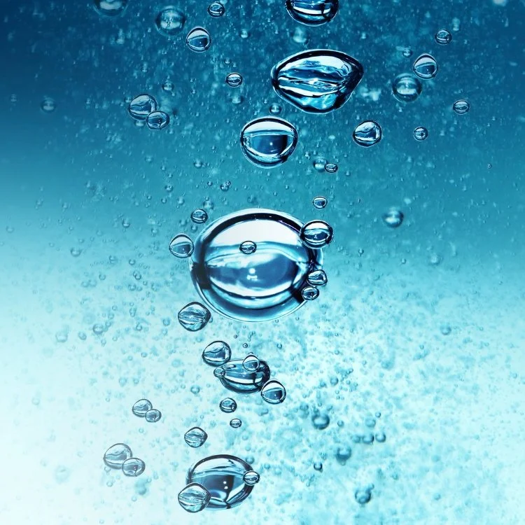 Bubbles rising in clear blue water.
