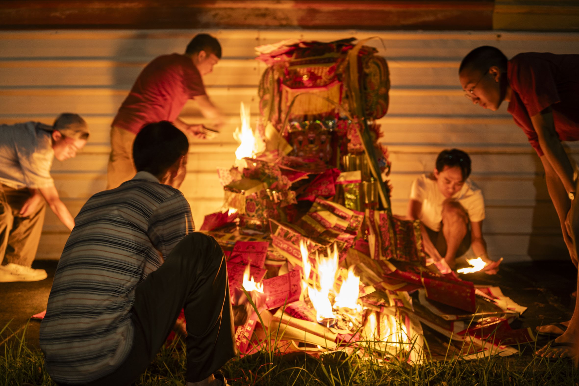 When it was time, the devotees carried stacks of offerings and a grand paper palace to a sidewalk and began piling them. Upon lighting, the pile blazed wildly and the devotees watched from a distance, muttering prayers under their breath.