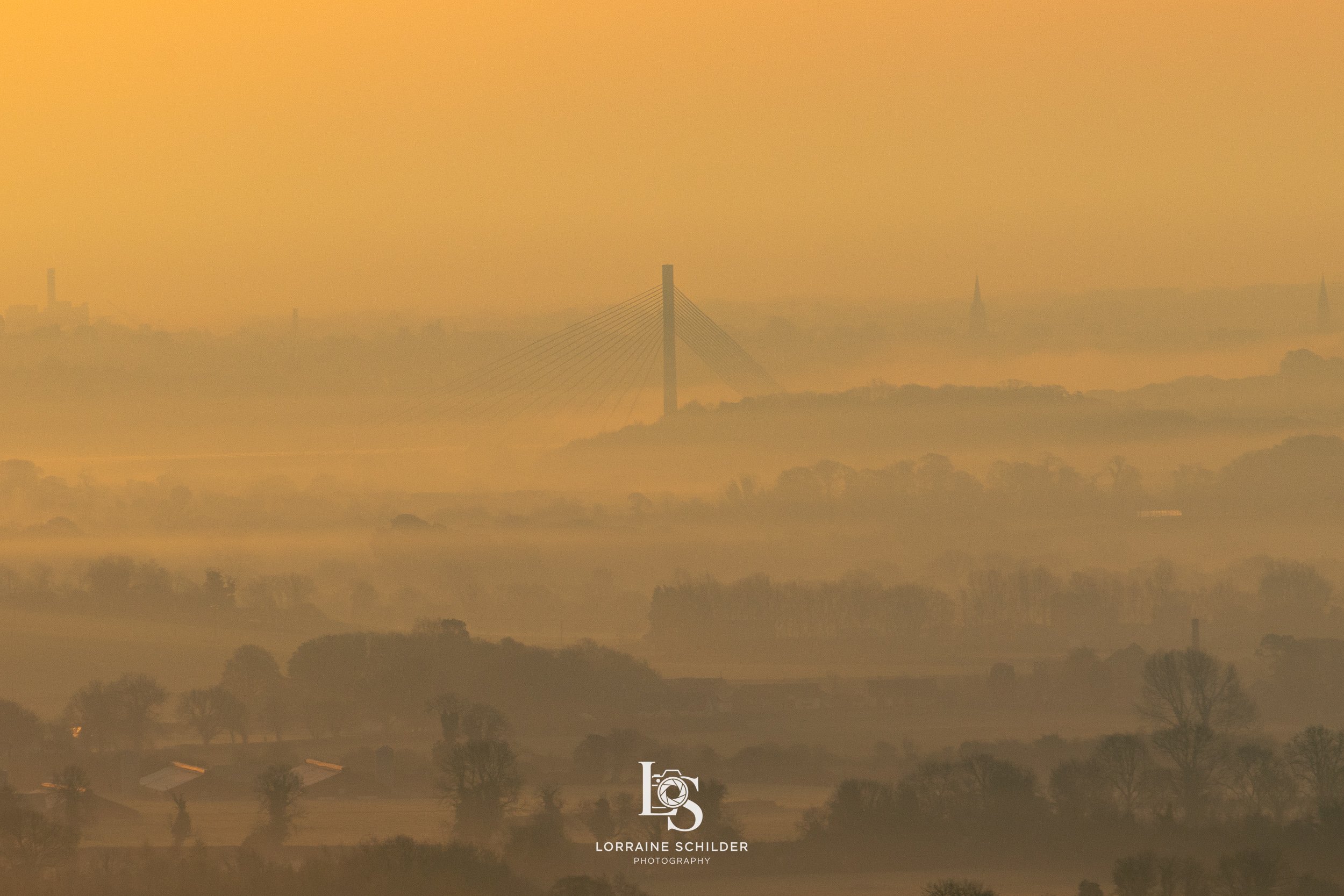 Landscape with hazy view of a bridge and distant buildings on a foggy morning.  Slane, Meath