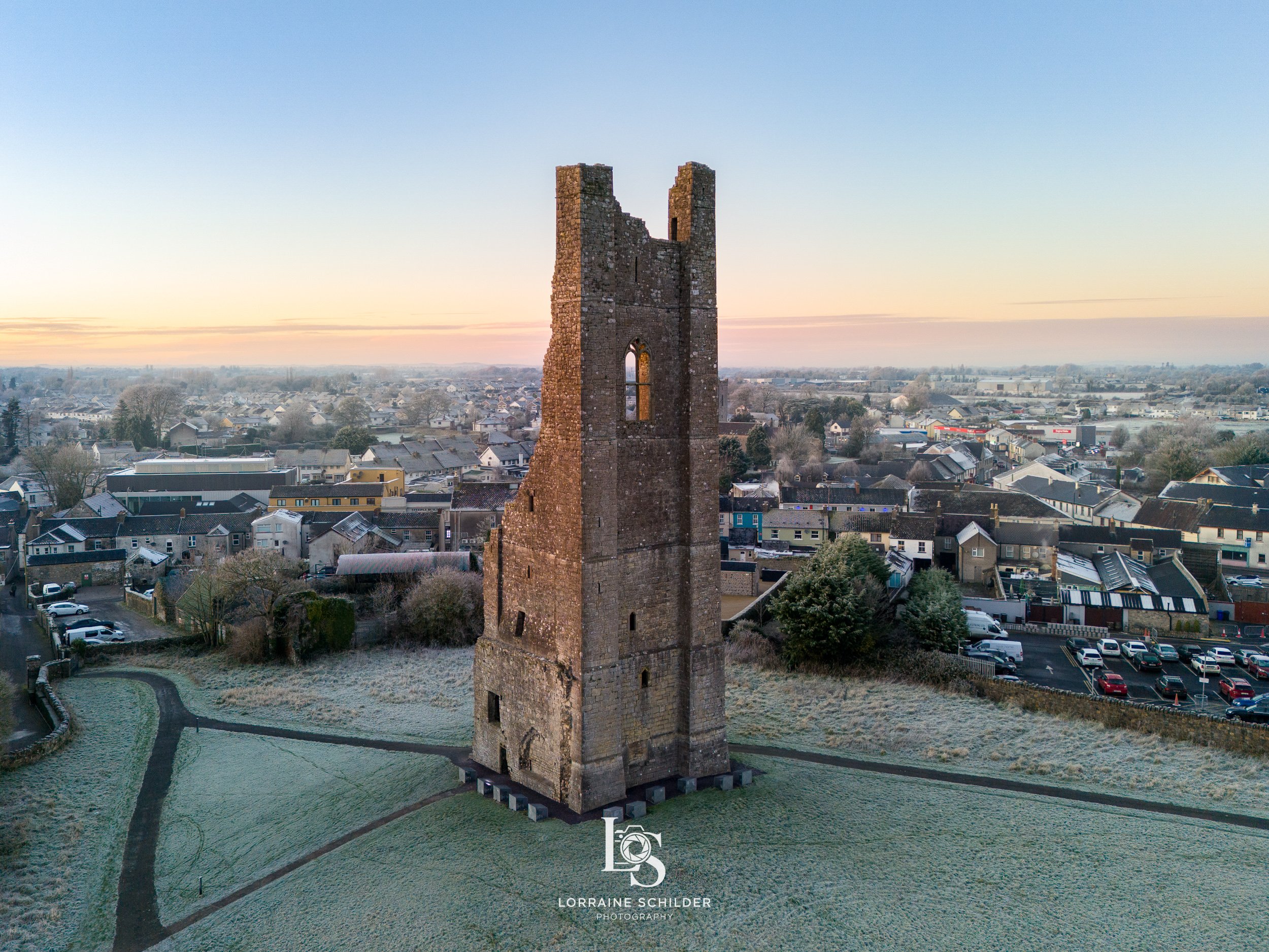 The Yellow Steeple on a grassy area with pathways, overlooking a suburban town at sunrise. Trim, Meath.