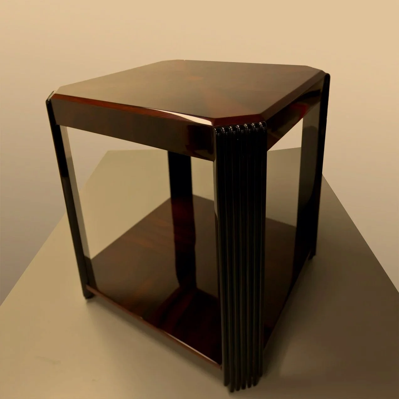 Ein dunkler Artdeco Luxus Beistelltisch mit einer quadratischen Form und glänzender, hochwertig polierter Oberfläche