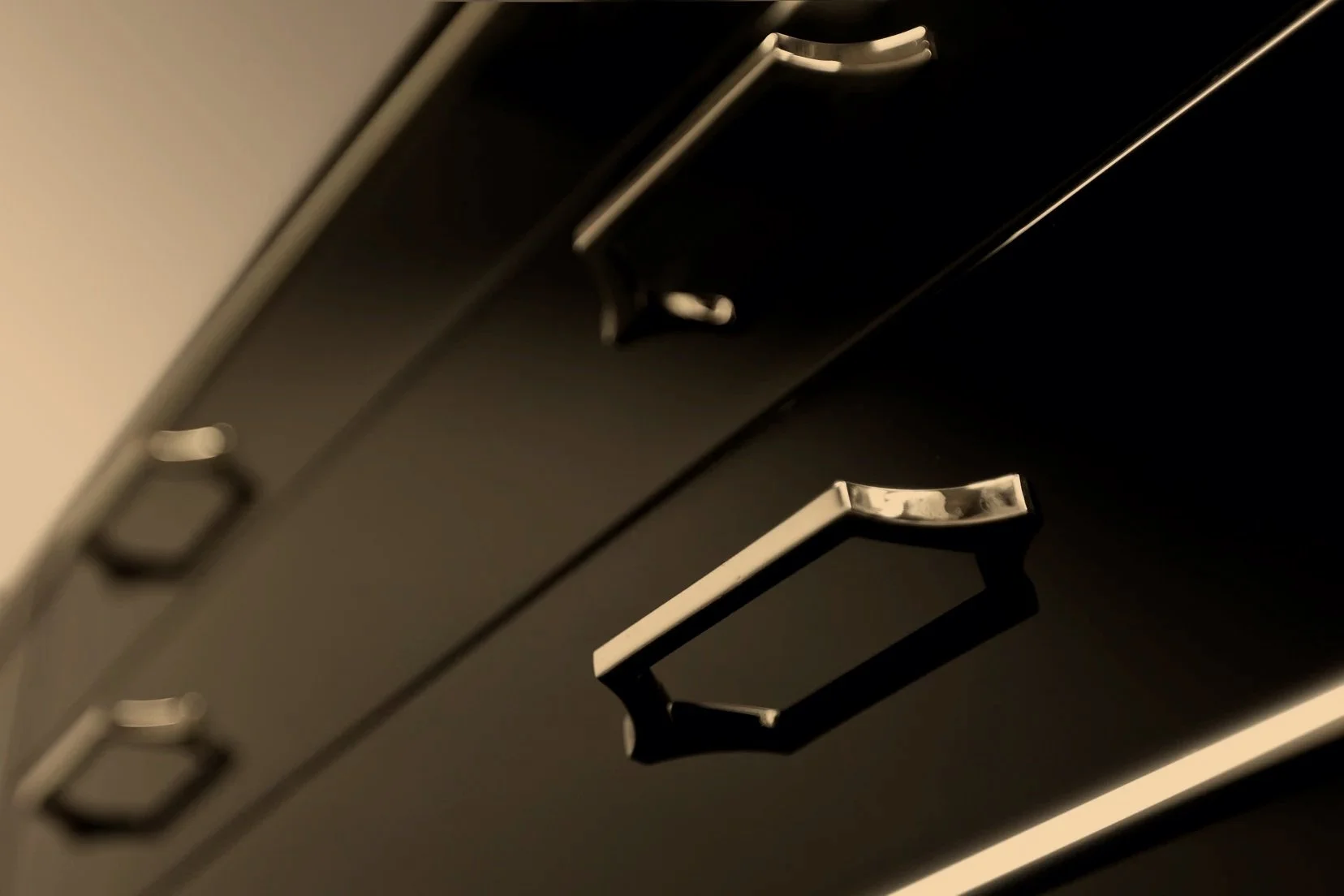 Nahaufnahme eines schwarzen, hochglanzoberflächigen, Artdeco Sideboards mit polierten Chromgriffen.
