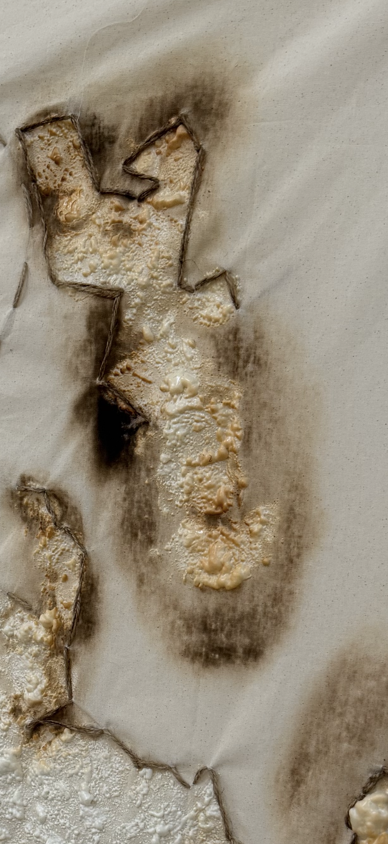 Close-up of textured, melted cheese on paper with burnt edges.