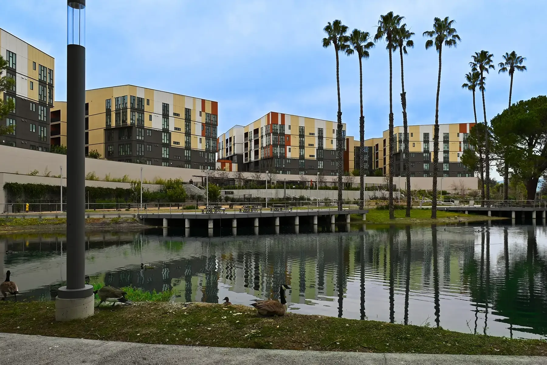 another wide view of the lakeside building with lake and palm trees in foreground
