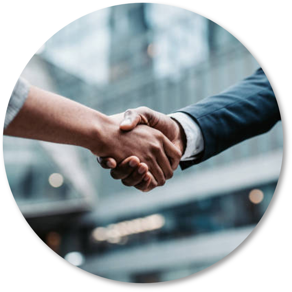 Apretón de manos entre dos personas con trajes formales en un entorno profesional.