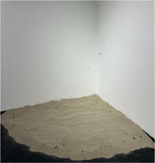 Lily Shea 
Hidden Gems, 2025
Nylon String, wire, clear iridescent beads, sea glass, plastic bags, and sand

This piece is a reflection of all the memories held during beach trips with my family and our ongoing tradition of collecting sea glass each t