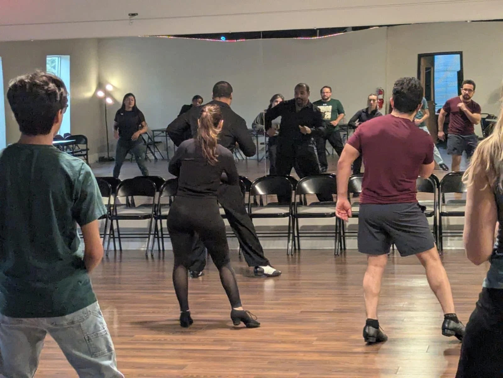 People practicing dance moves in a dance studio.