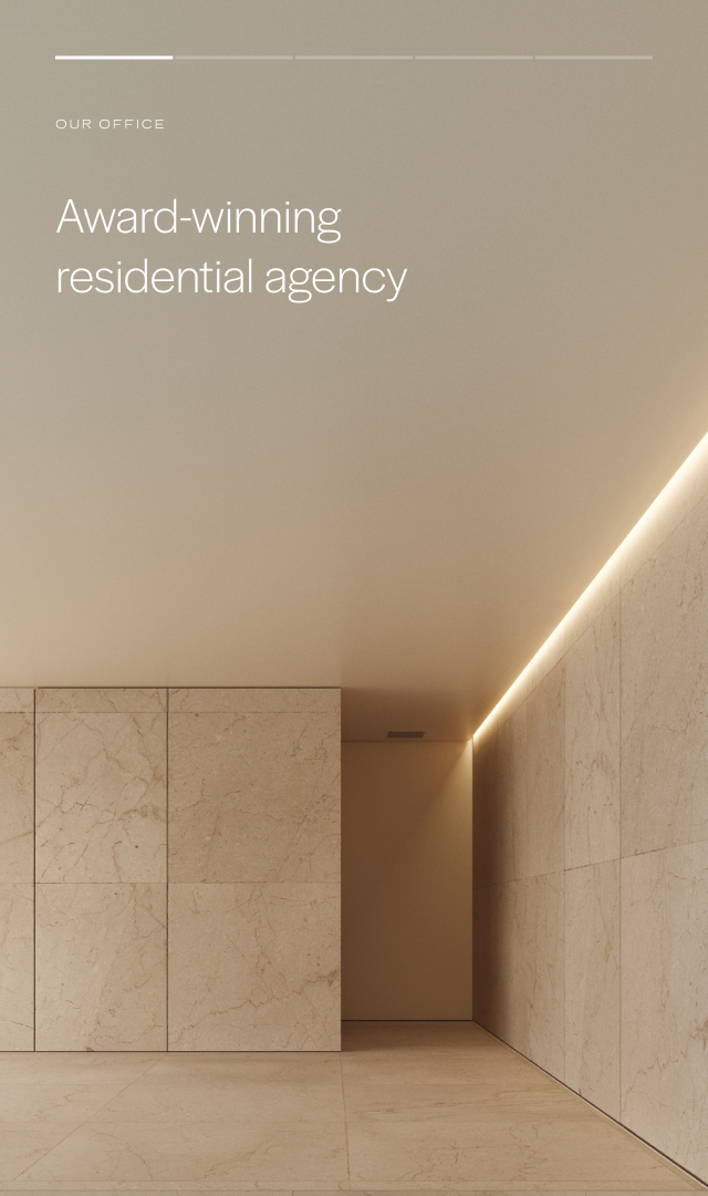 Modern, minimalist office interior with beige marble walls and a soft glow of indirect lighting along the ceiling corner.