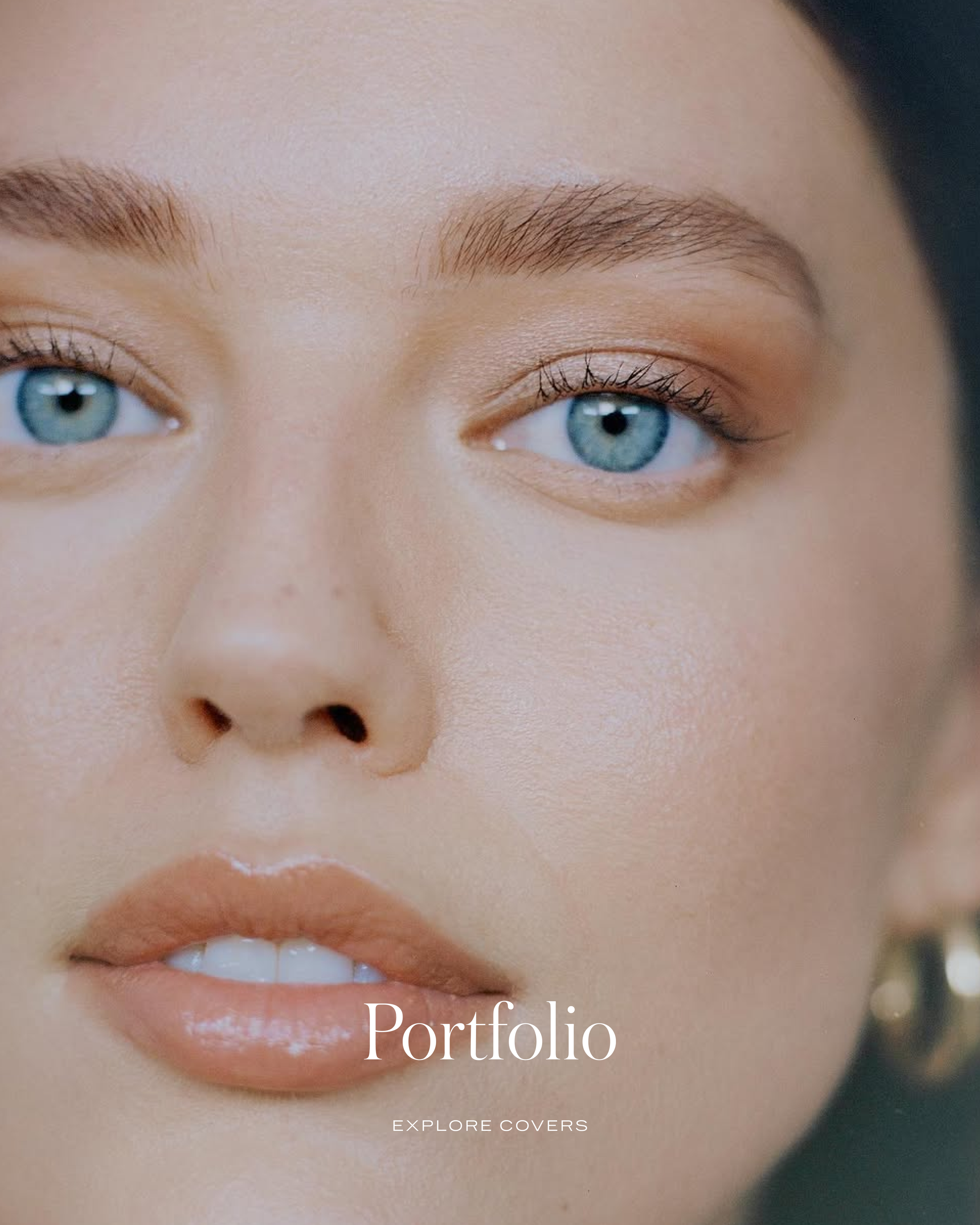 Close-up of a woman's face with blue eyes, light makeup, and natural eyebrows, with the word 'Portfolio' and 'Explore Covers' written on the image.