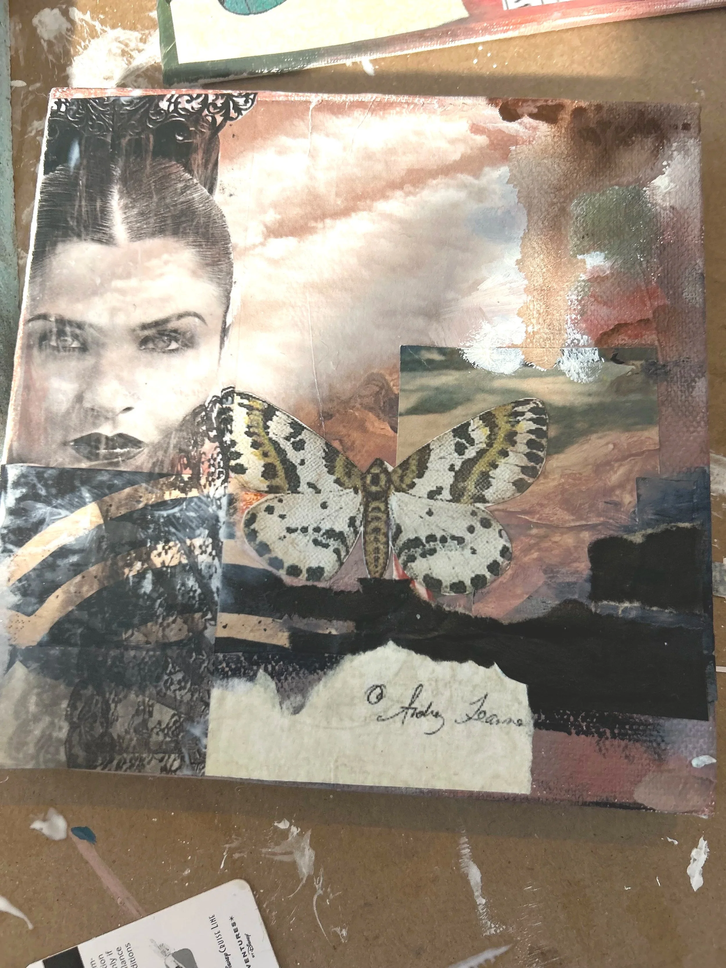 Mixed media collage featuring a black-and-white photo of a woman with dark hair, a colorful butterfly, a landscape painting, and a handwritten signature '© Andy Fontaine'.