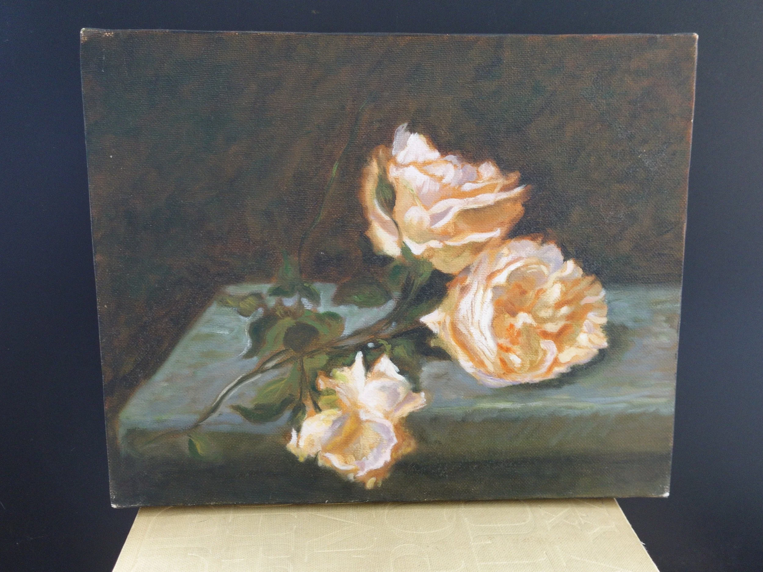 An oil painting of three roses with light-colored petals and dark green leaves, resting on a light surface against a dark background.