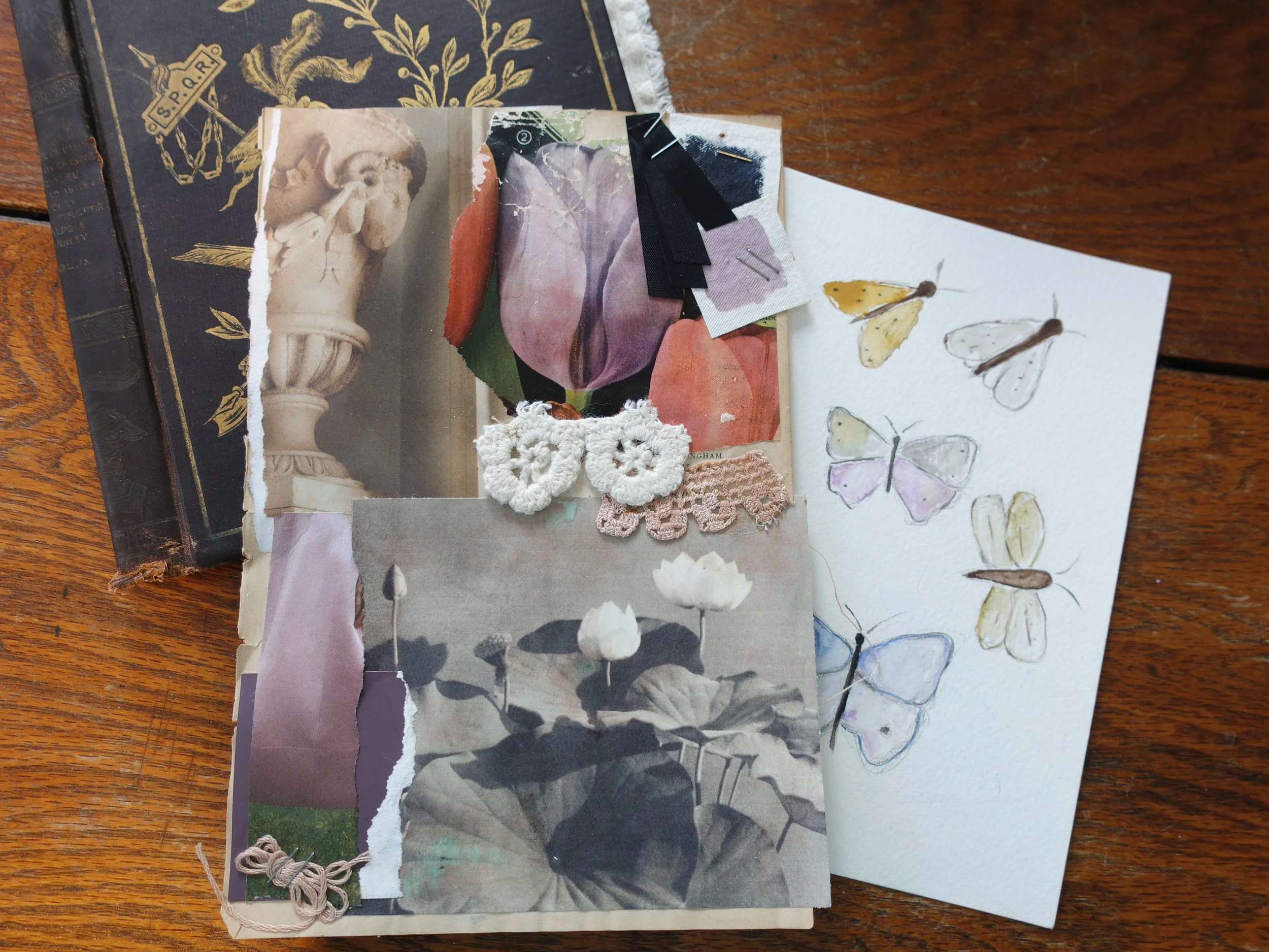 A collage of torn magazine pages, botanical images, lace and crochet fabric pieces, and watercolor butterfly illustrations on a wooden surface.