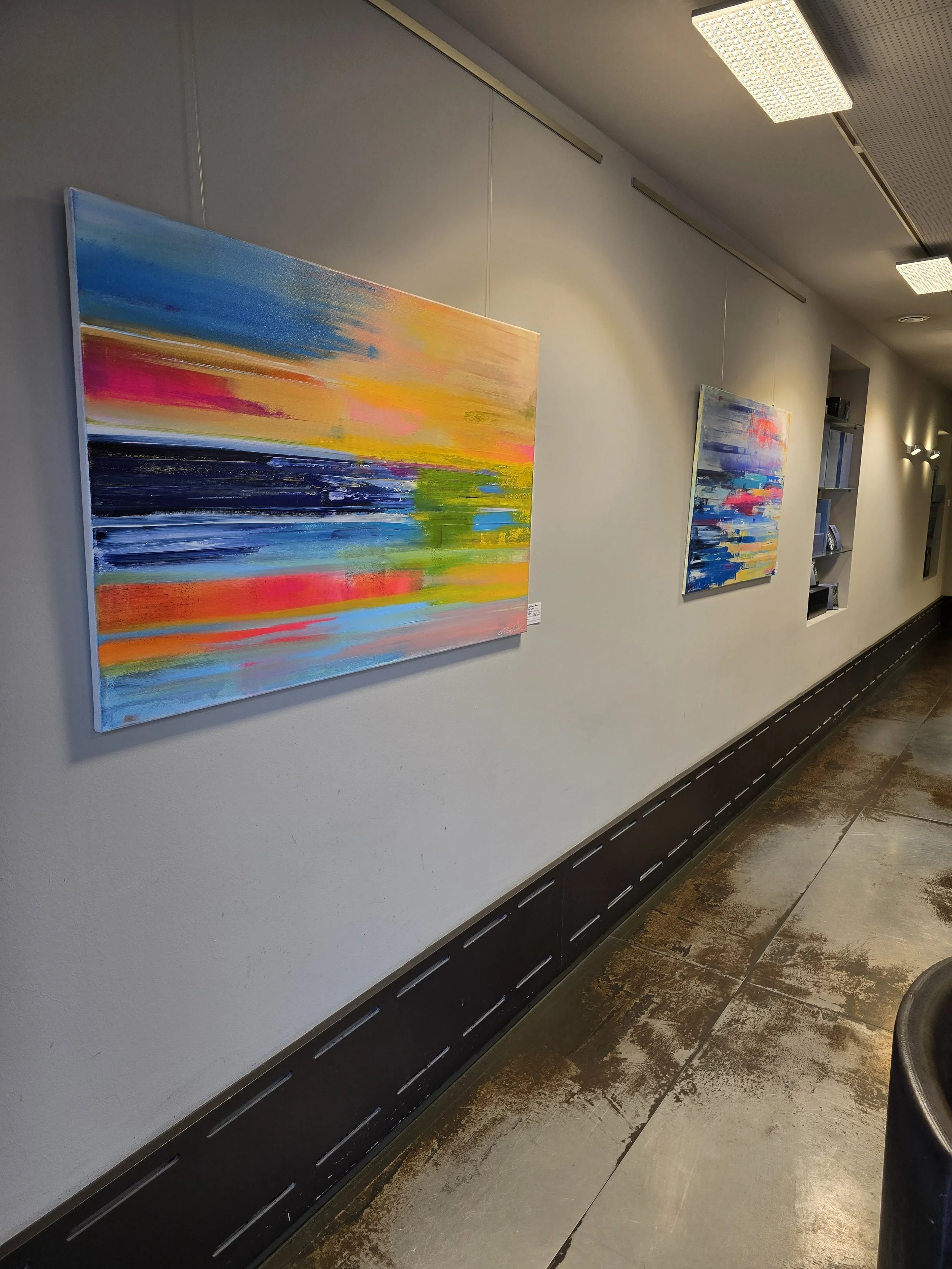 Abstrakte Gemälde der Künstlerin Stefanie Rau aus der Serie "Horizons" - Urlaubsreflexionen hängen an einer Wand in der Stylemanufaktur Ichenhausen. 