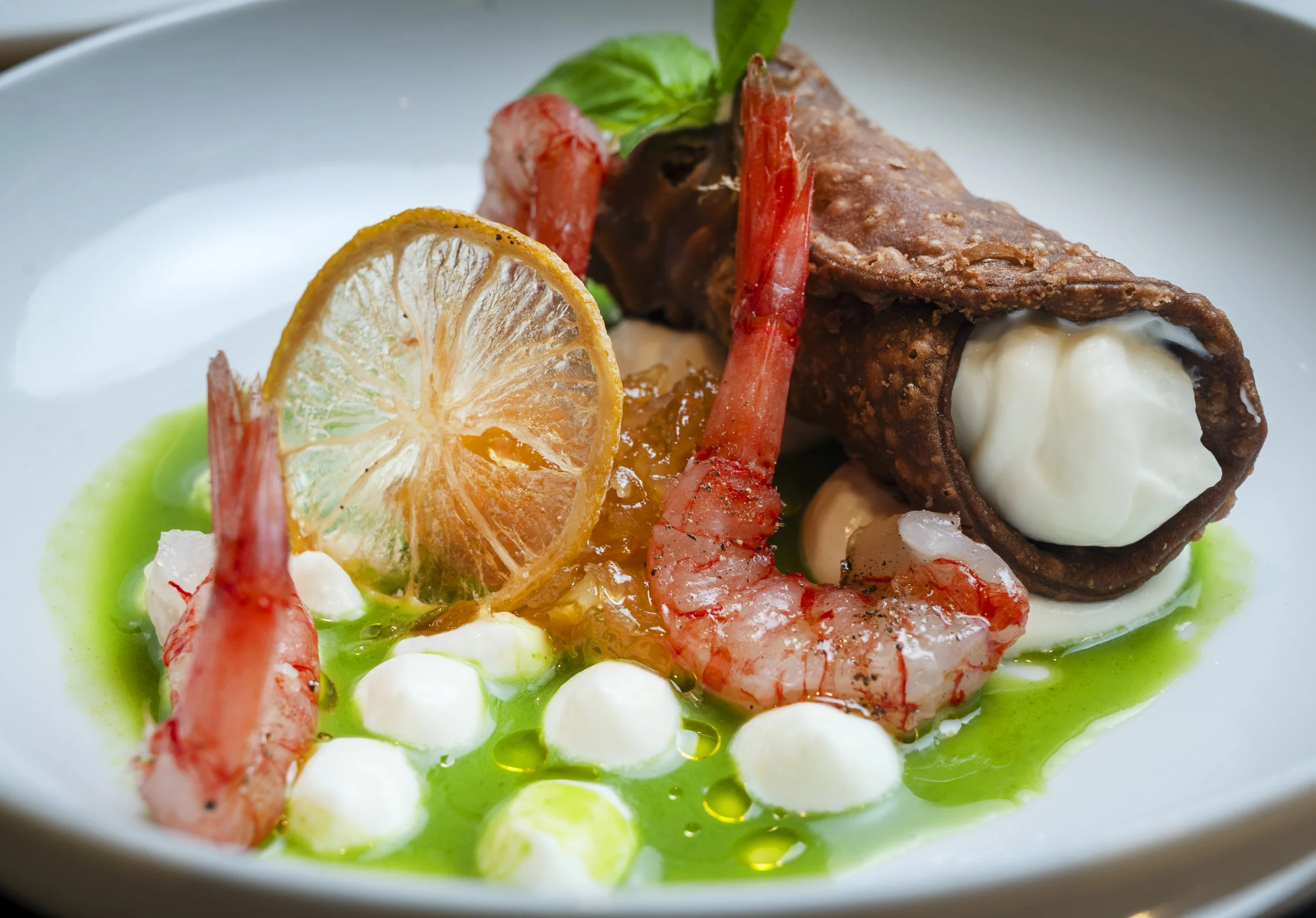 Piatti di pesce con limone, pomodorini, erbe e crema di yogurt o panna, su piatto bianco