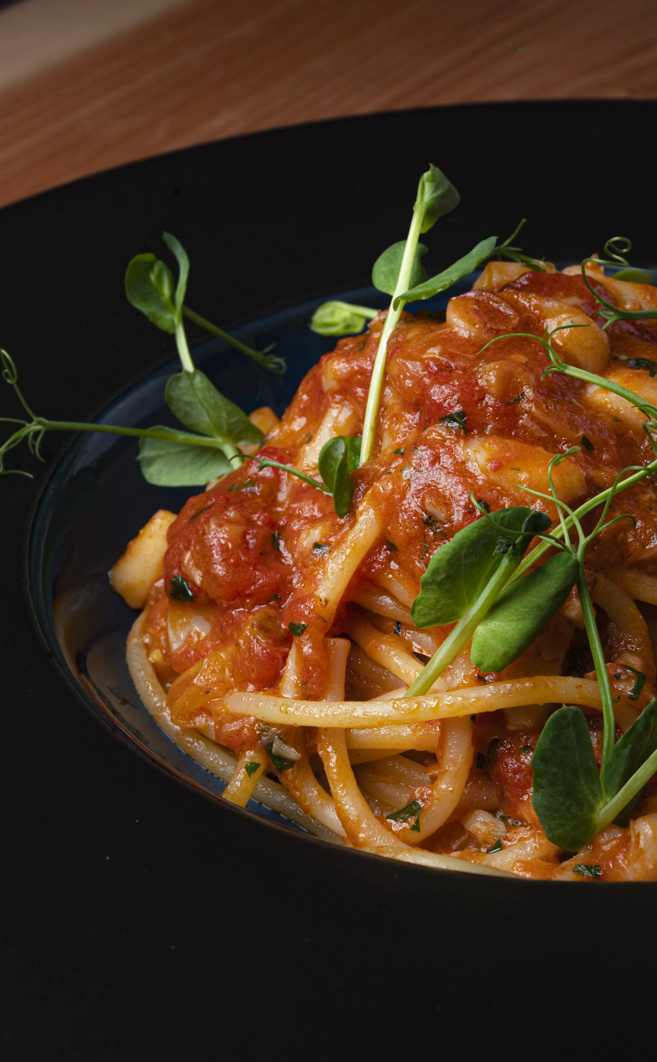 Pasta con salsa di pomodoro decorata con germogli verdi