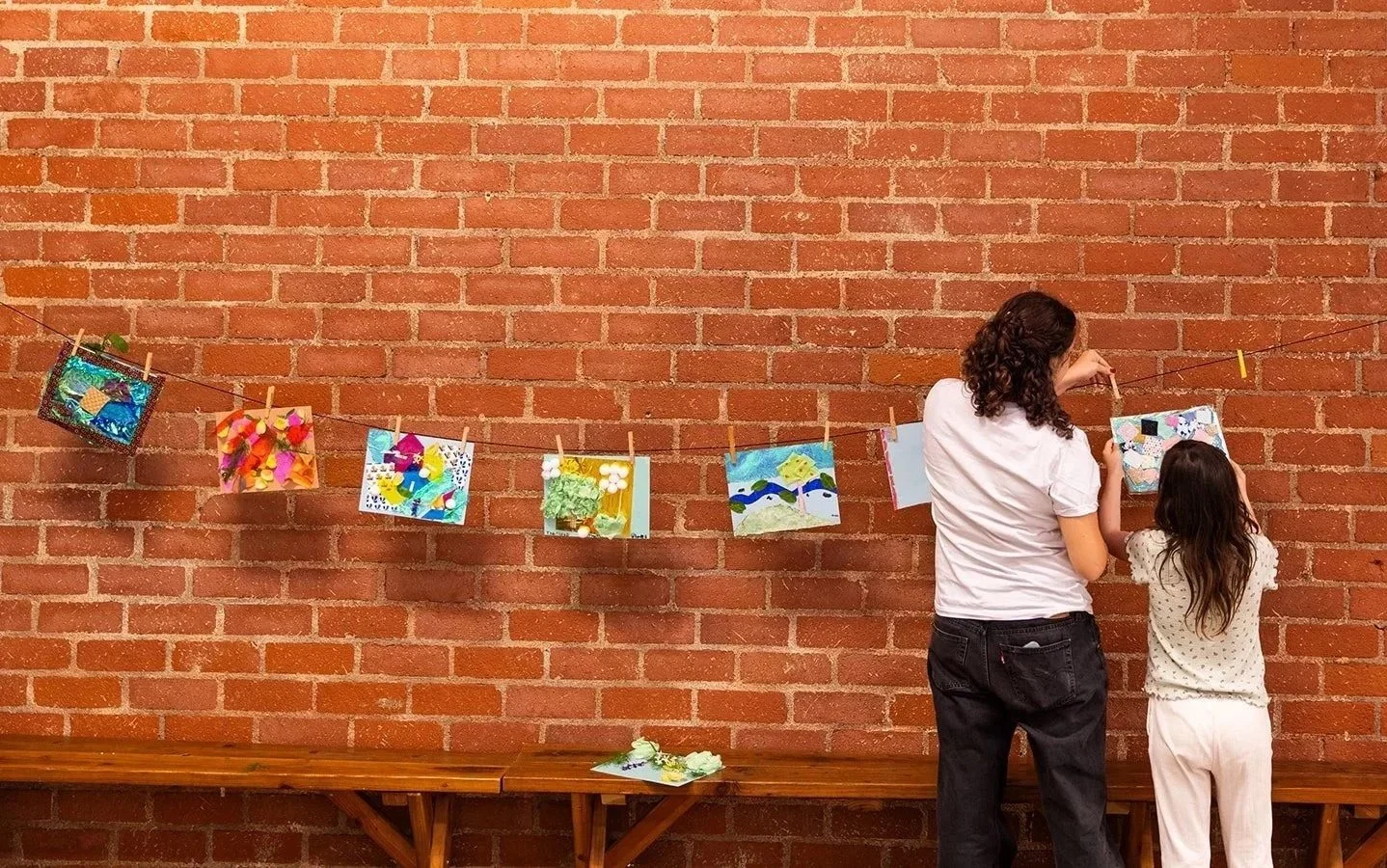 Blue Heron inspired art pieces hanging from a brick wall