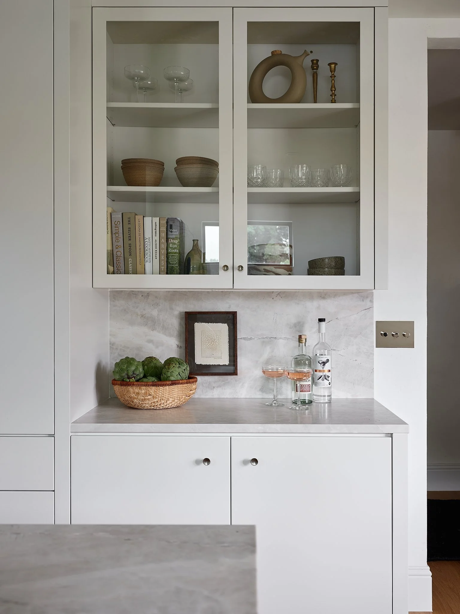 Custom interior design by Sarah Hart Interior Design in Charleston, including Minimalist Chateau kitchen renovation with La Cornue range, SubZero fridge, marble countertops, and bespoke window treatments.