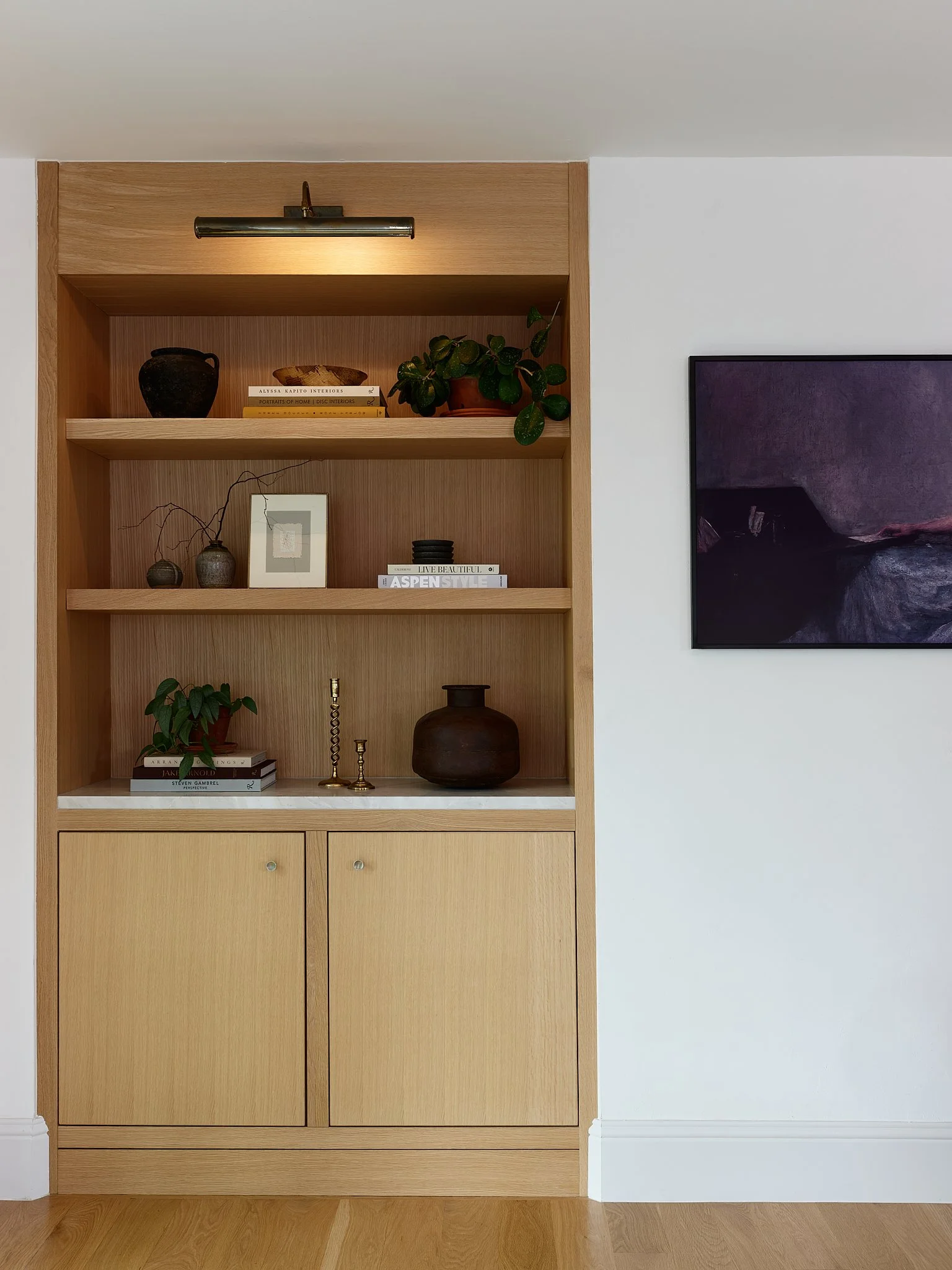 Full-home luxury interior design project by Charleston-based Sarah Hart, featuring the Minimalist Chateau with custom kitchen, marble countertops, custom range hood, plaster walls, and high-end appliances. Custom built in in Living Room. 