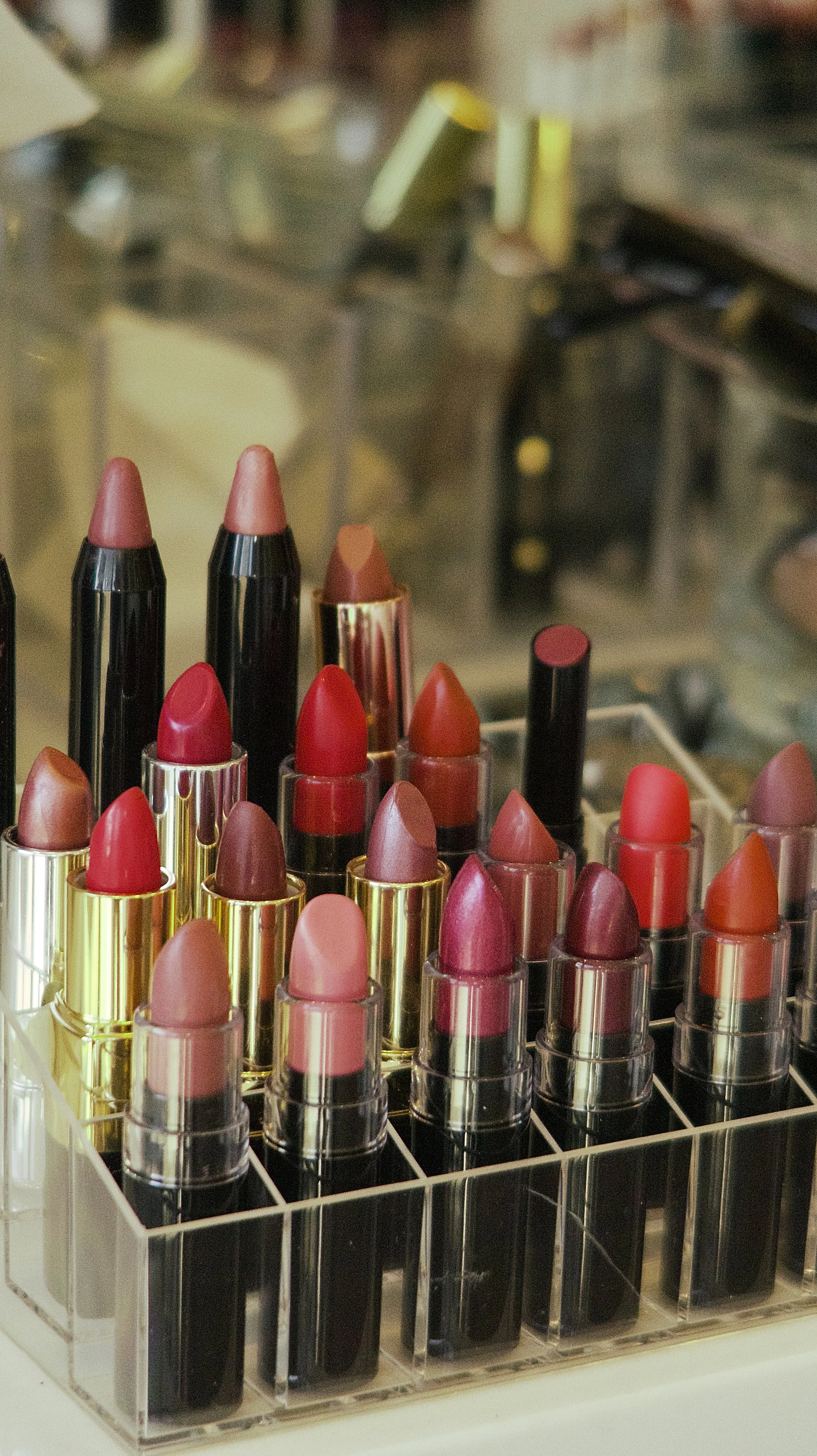 Collection of various shades of lipstick in a clear acrylic display case.