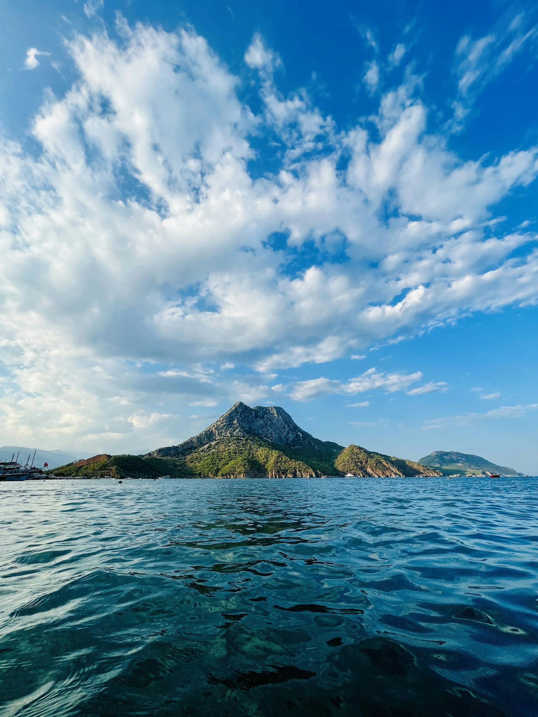 Scenic view of a mountain and water landscape under a partly cloudy sky.