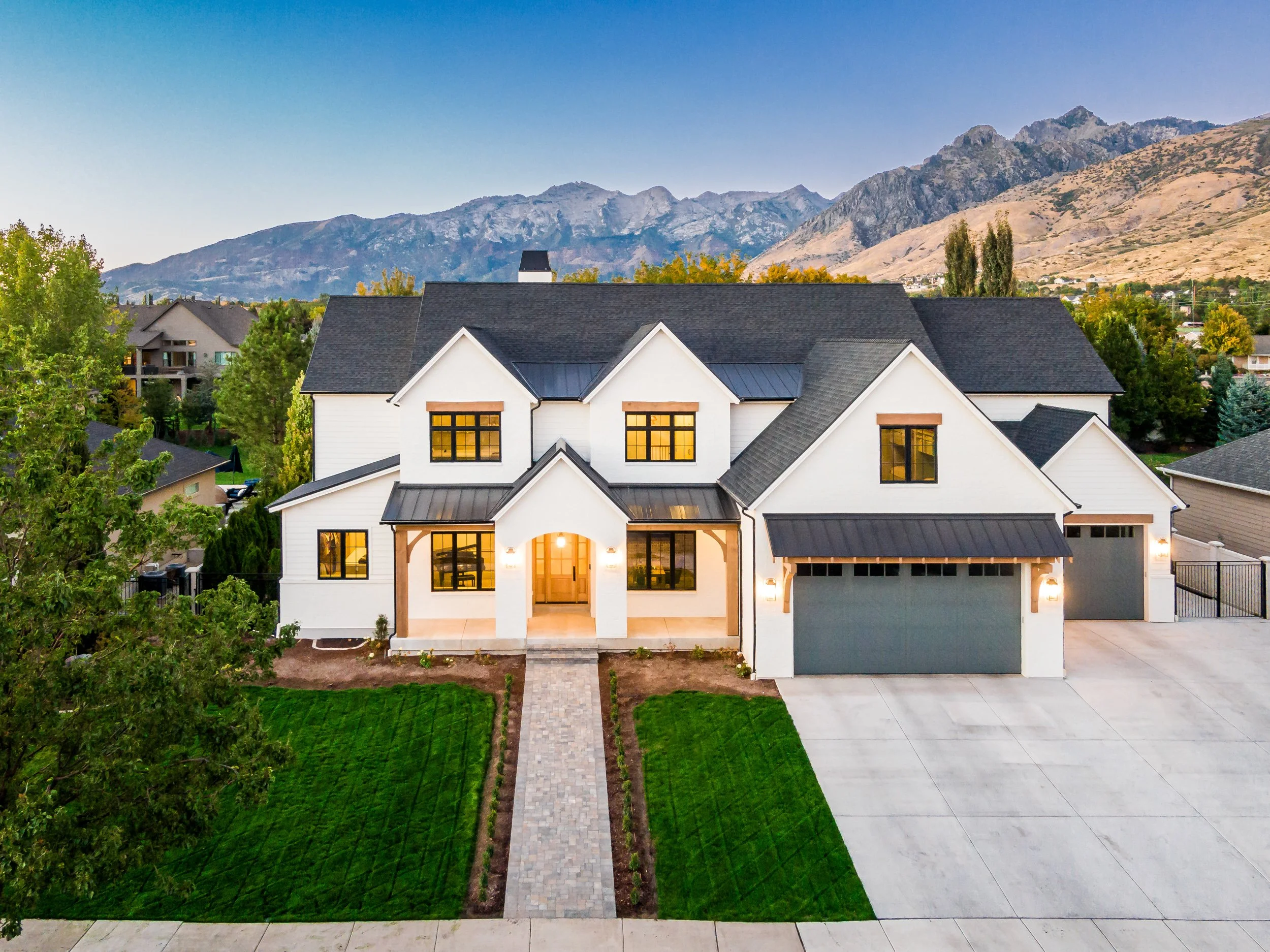 Custom home exterior with Wasatch Mountain backdrop at twilight — residential architectural photography by BK Captured