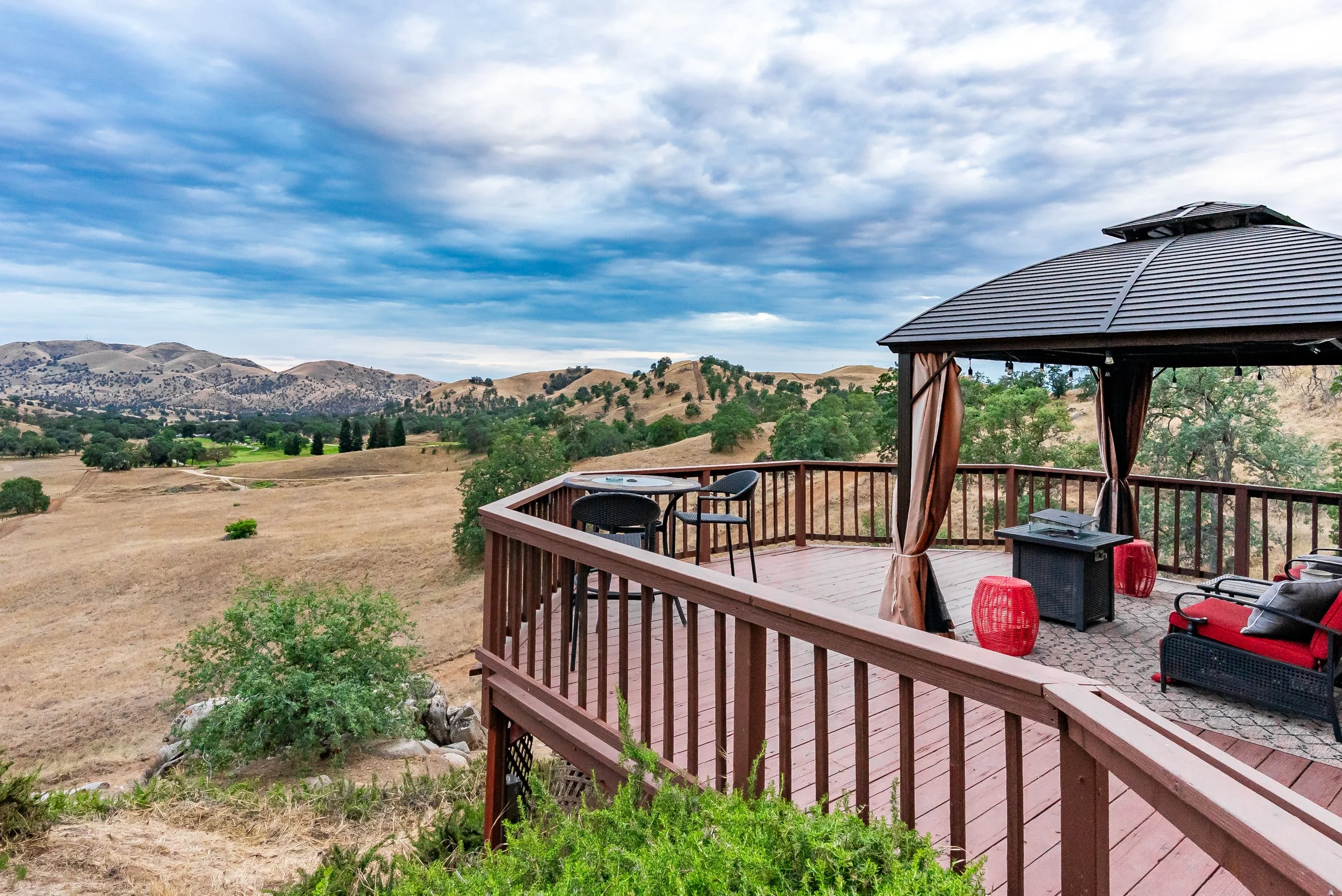Covered deck with gazebo overlooking oak-studded foothills and the Eagle Springs golf course at dusk