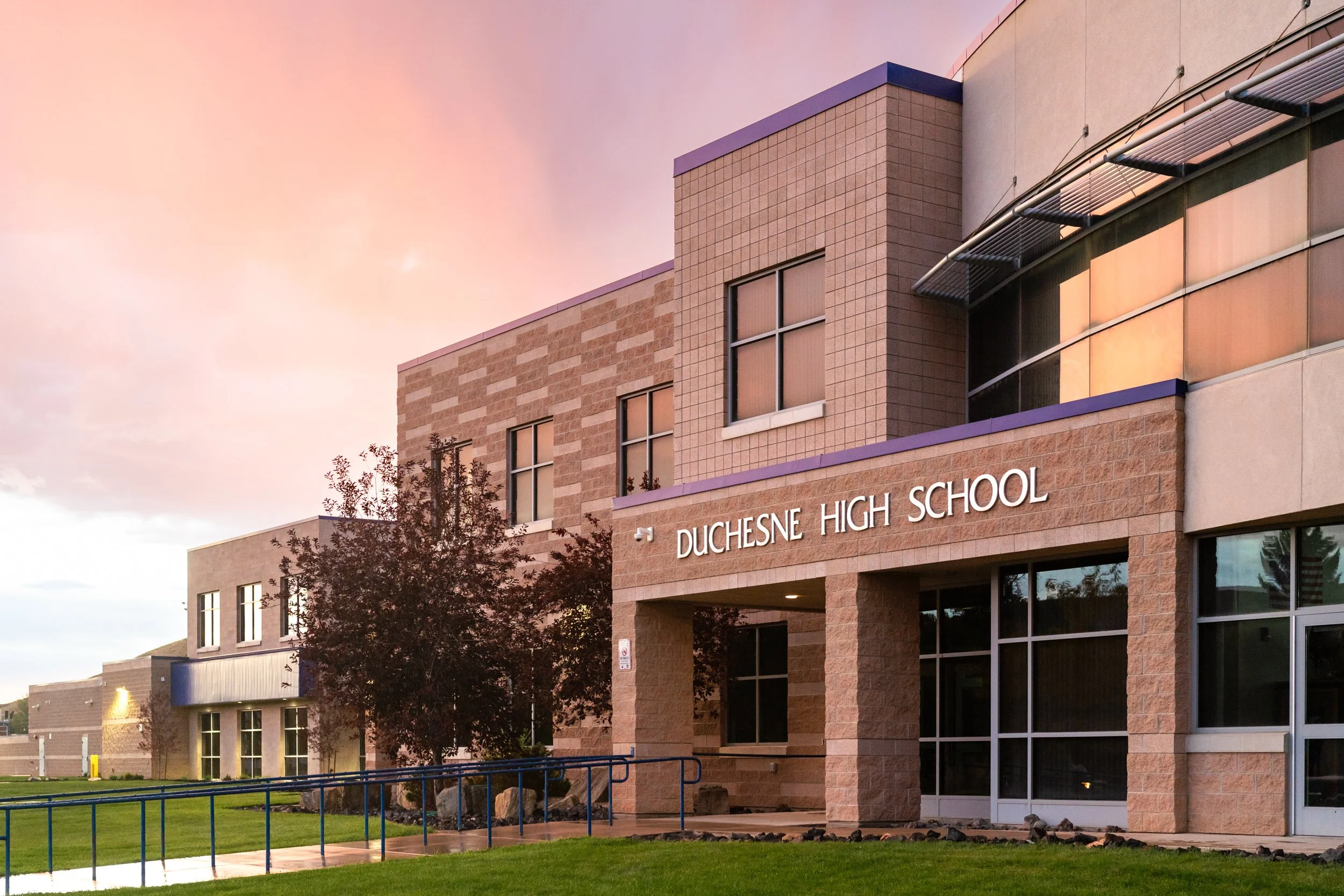 Duchesne high school brick exterior at dusk with dramatic sky — educational facility architectural photography by BK Captured
