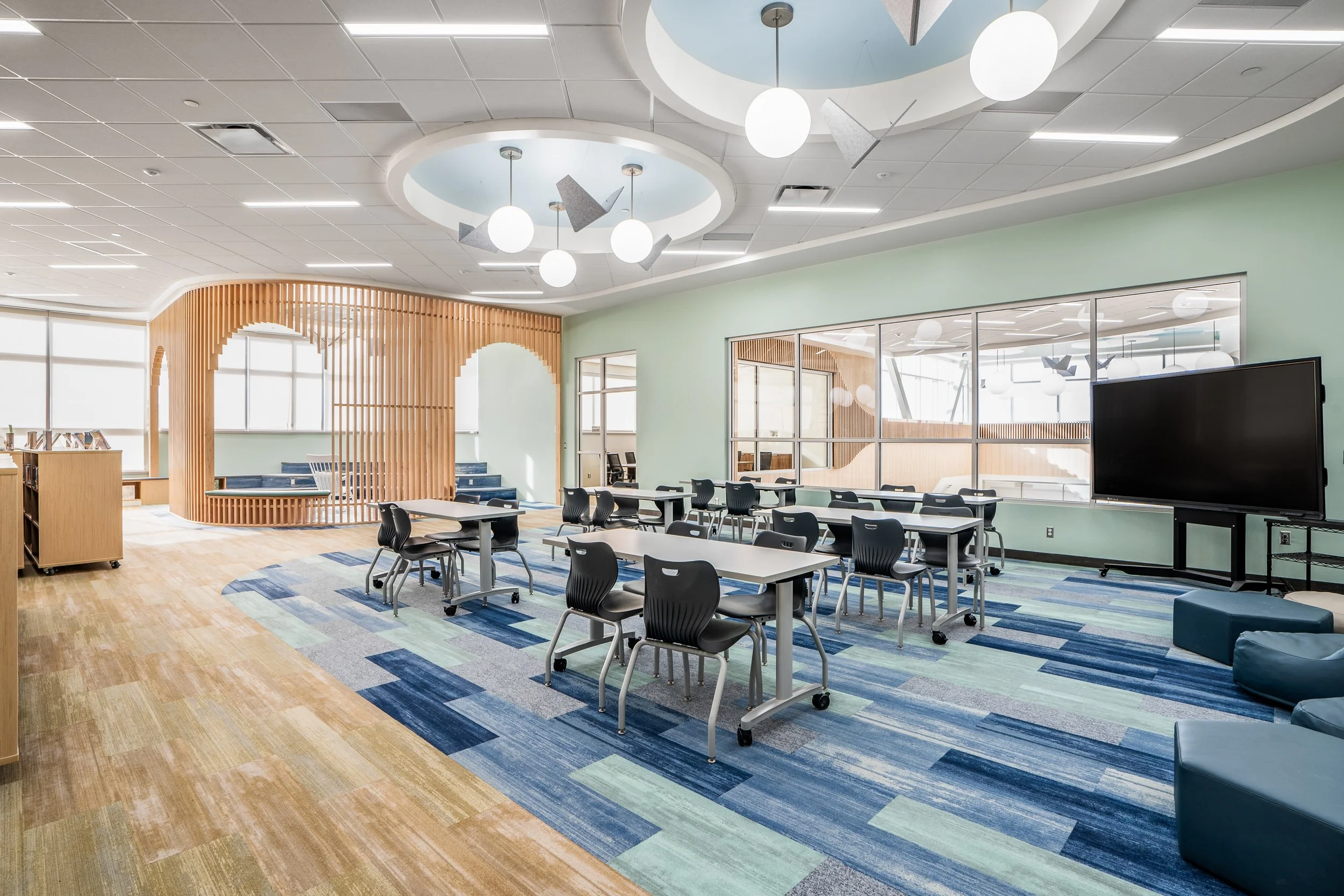 Modern library with large windows, task lighting, and collaborative seating — educational facility interior photography by BK Captured
