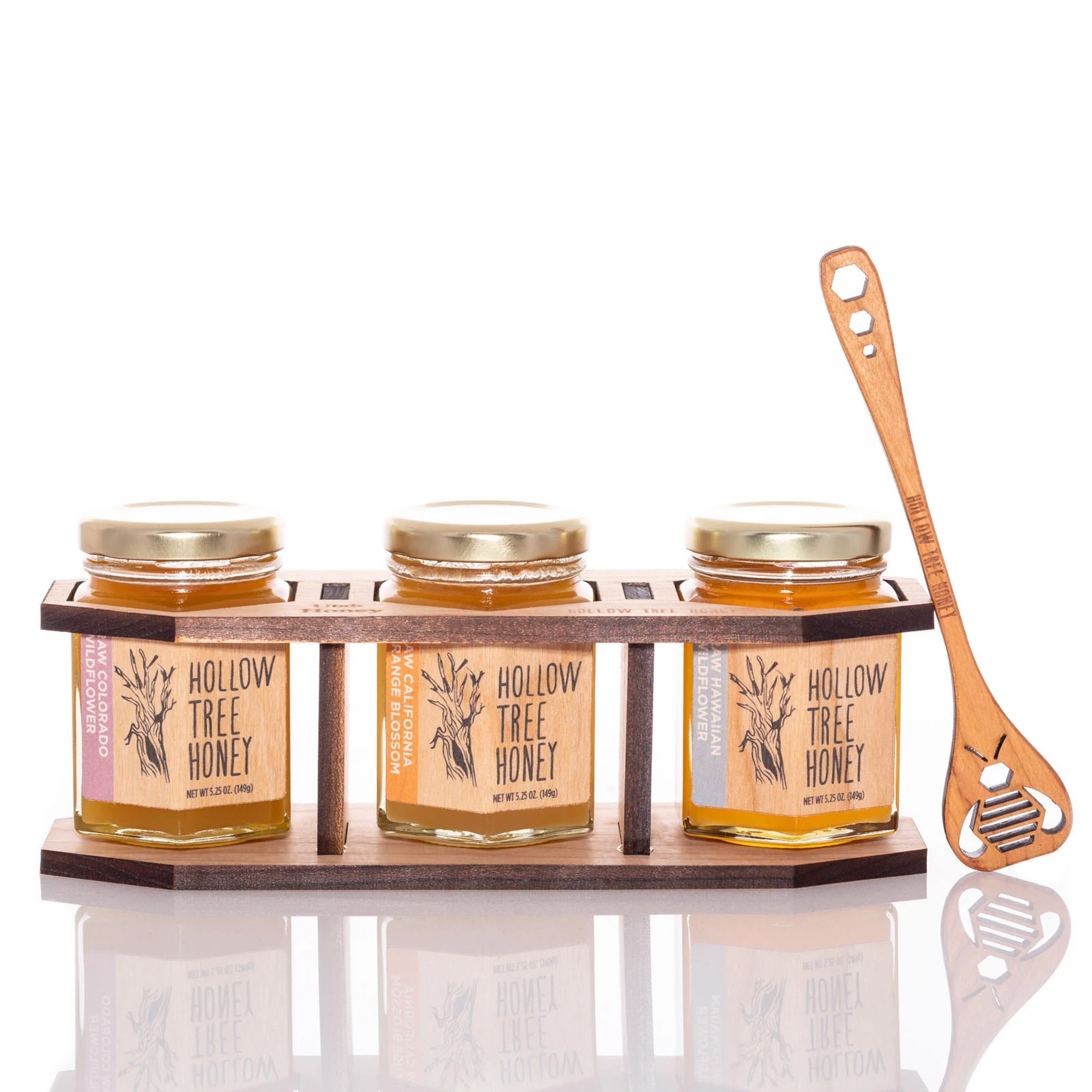 Three Hollow Tree honey jars displayed on a rustic wooden shelf with honey dipper — styled packaged goods photography by BK Captured