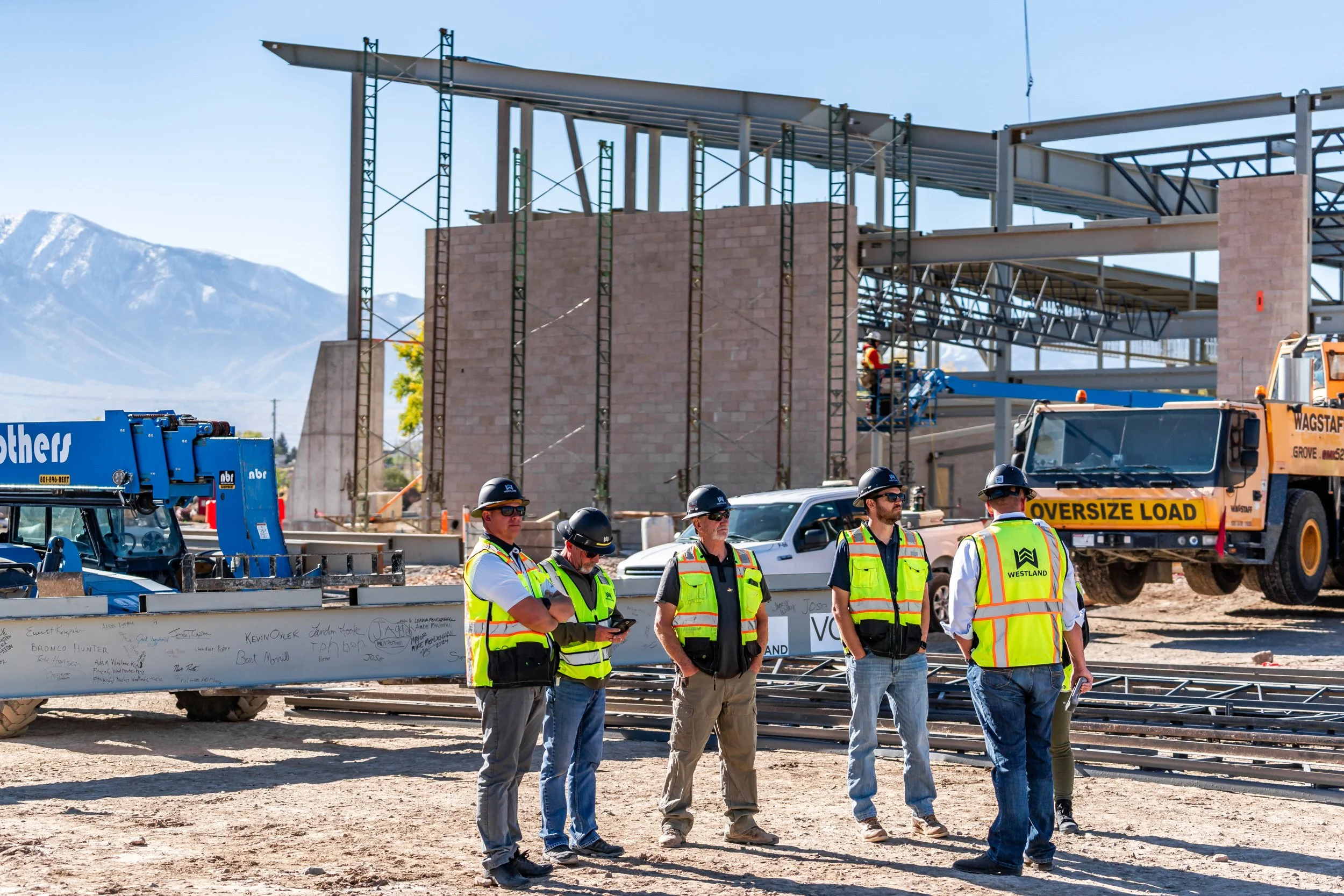 Westland construction workers in hard hats at ground level of active build site — commercial construction documentation by BK Captured