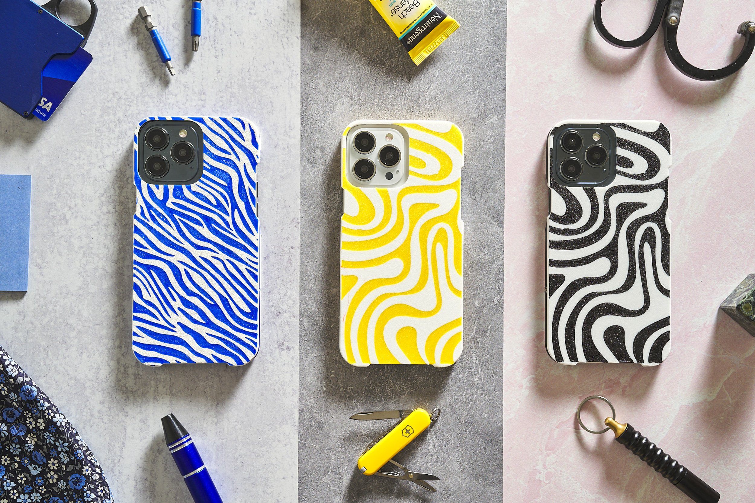 Three iPhone cases in blue, yellow, and zebra print patterns on white background — e-commerce product photography by BK Captured