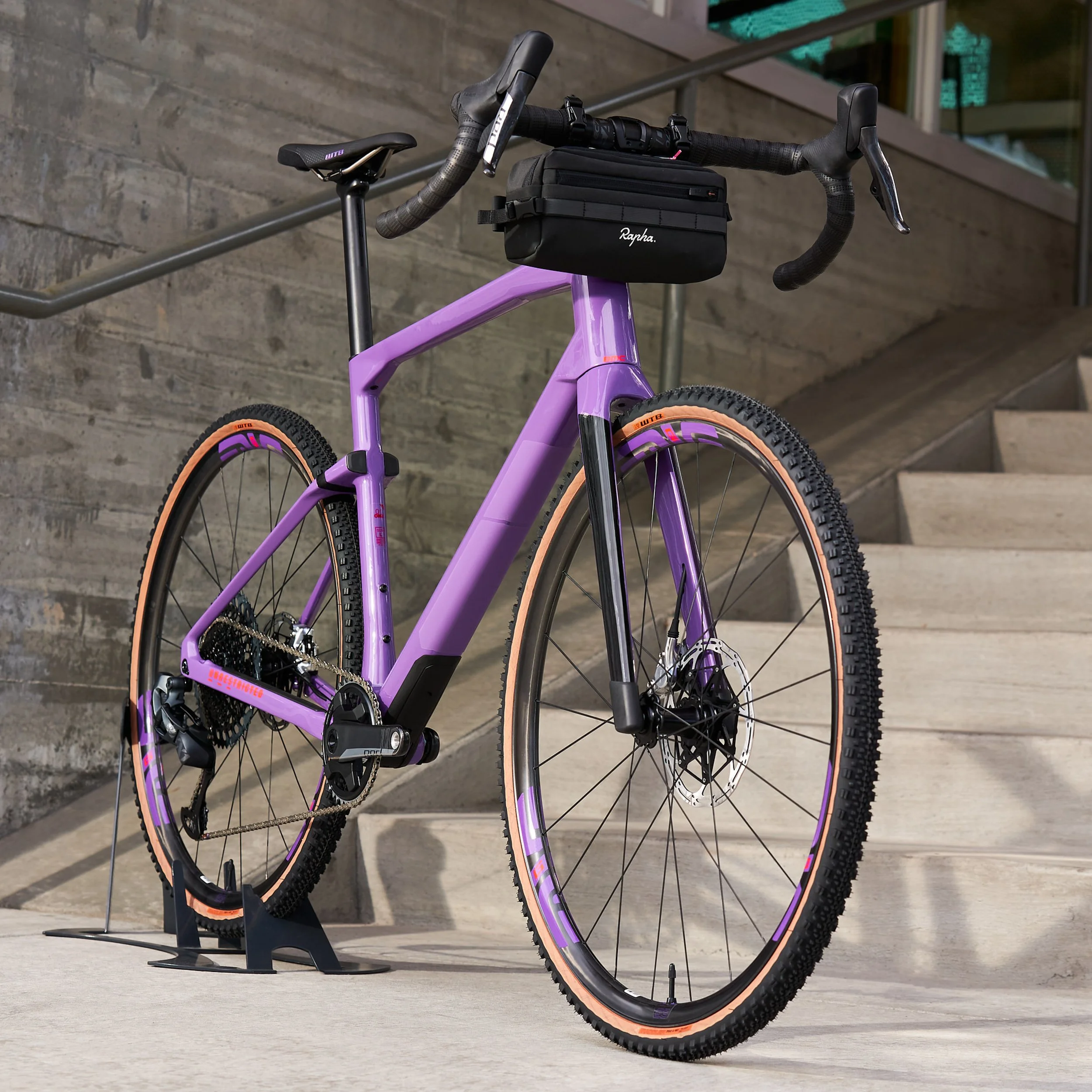 Purple gravel bike leaned against concrete stairs in urban setting — lifestyle product photography by BK Captured