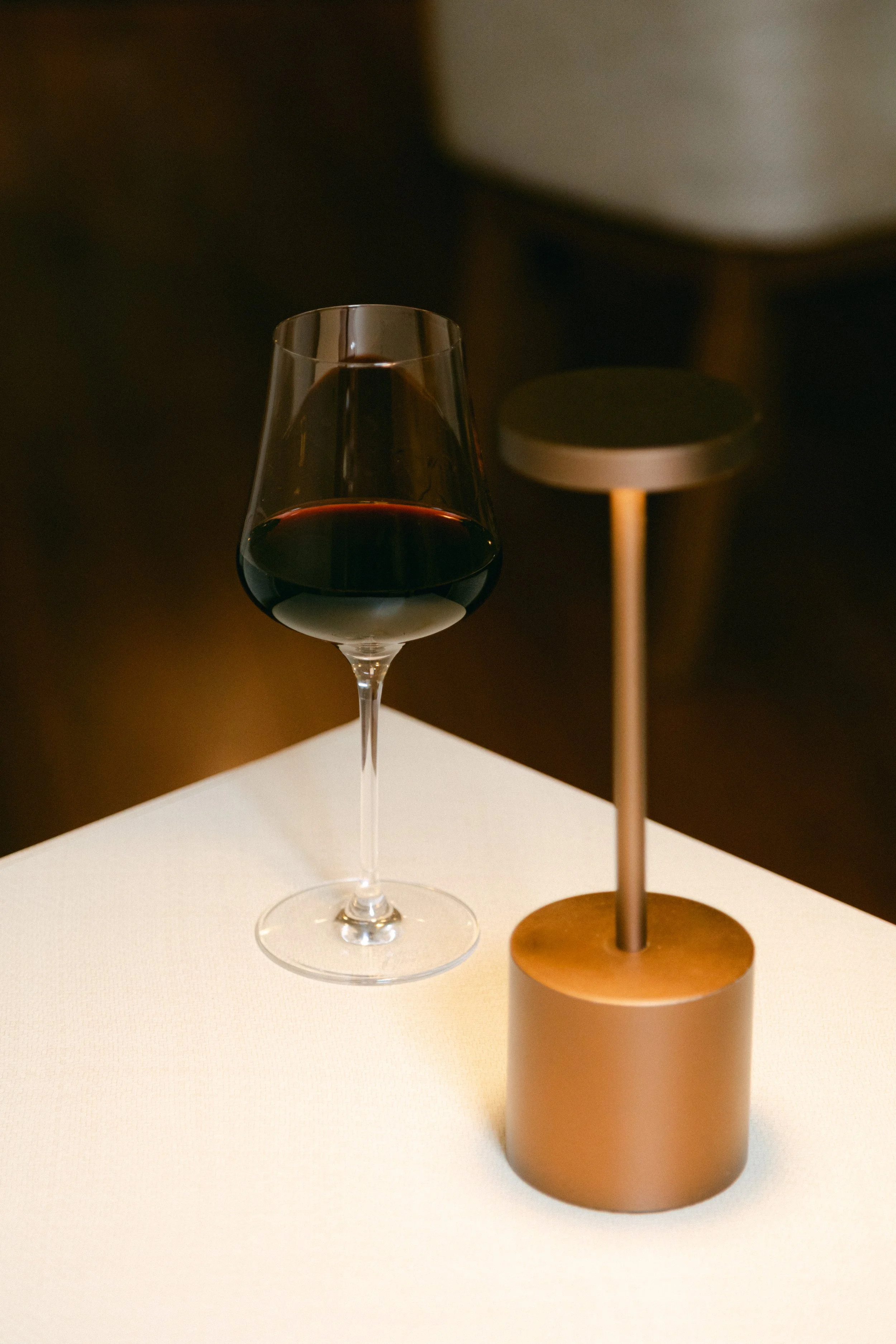 Copa de vino tinto sobre mesa blanca.